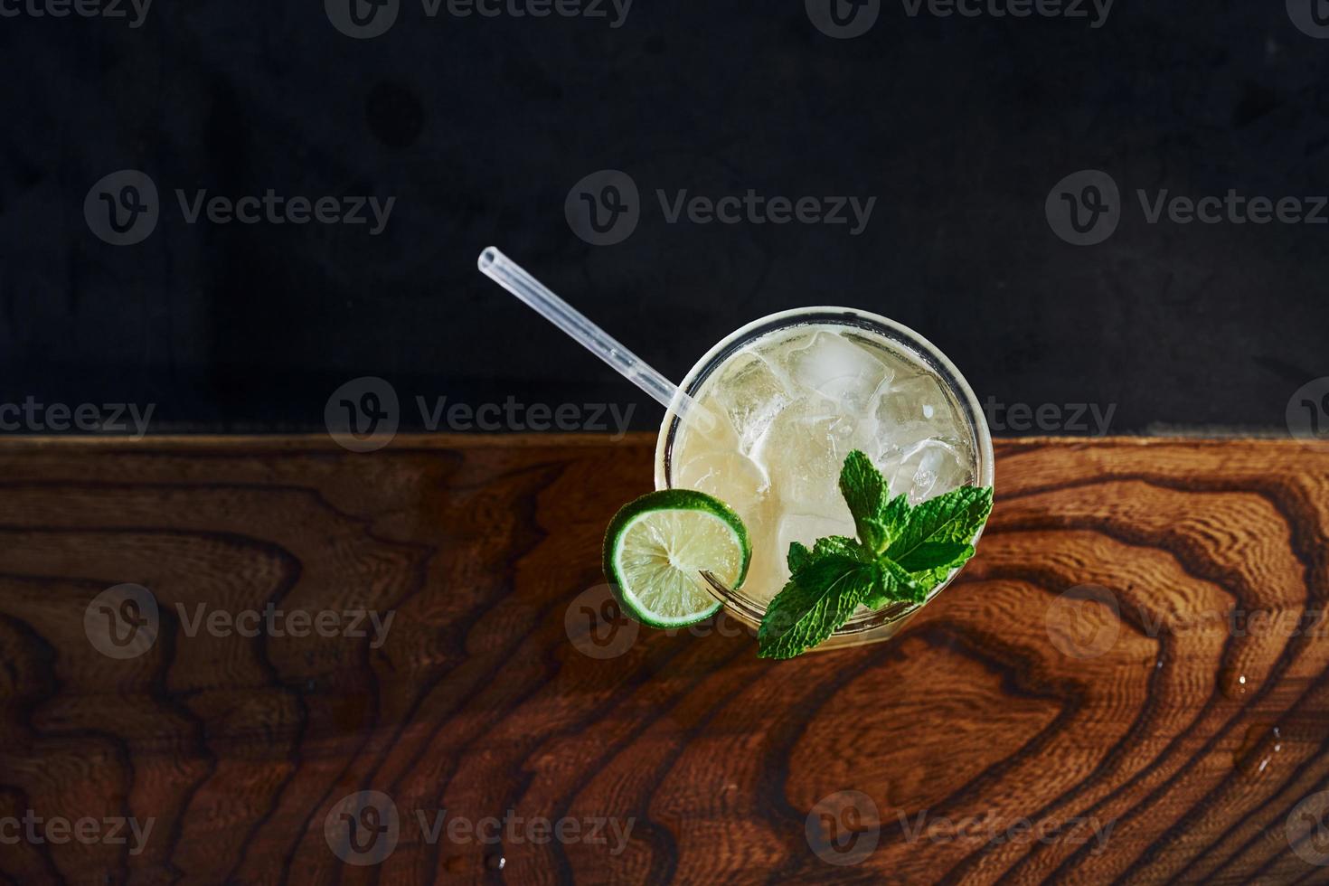 Green mint and yellow lime. Close up view of fresh summer cocktail on the wooden table photo