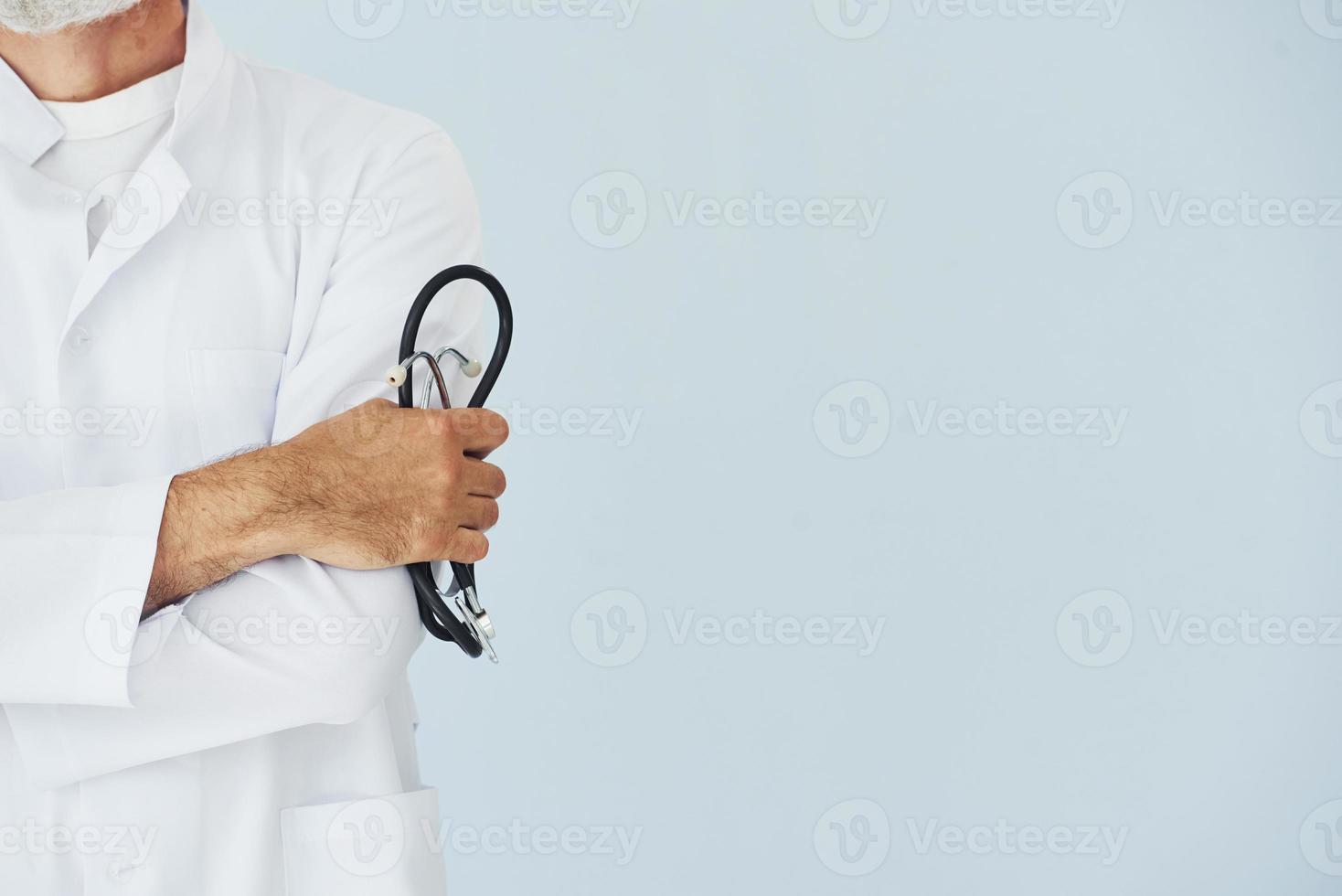 Close up view of male doctor in coat that holding stethoscope photo