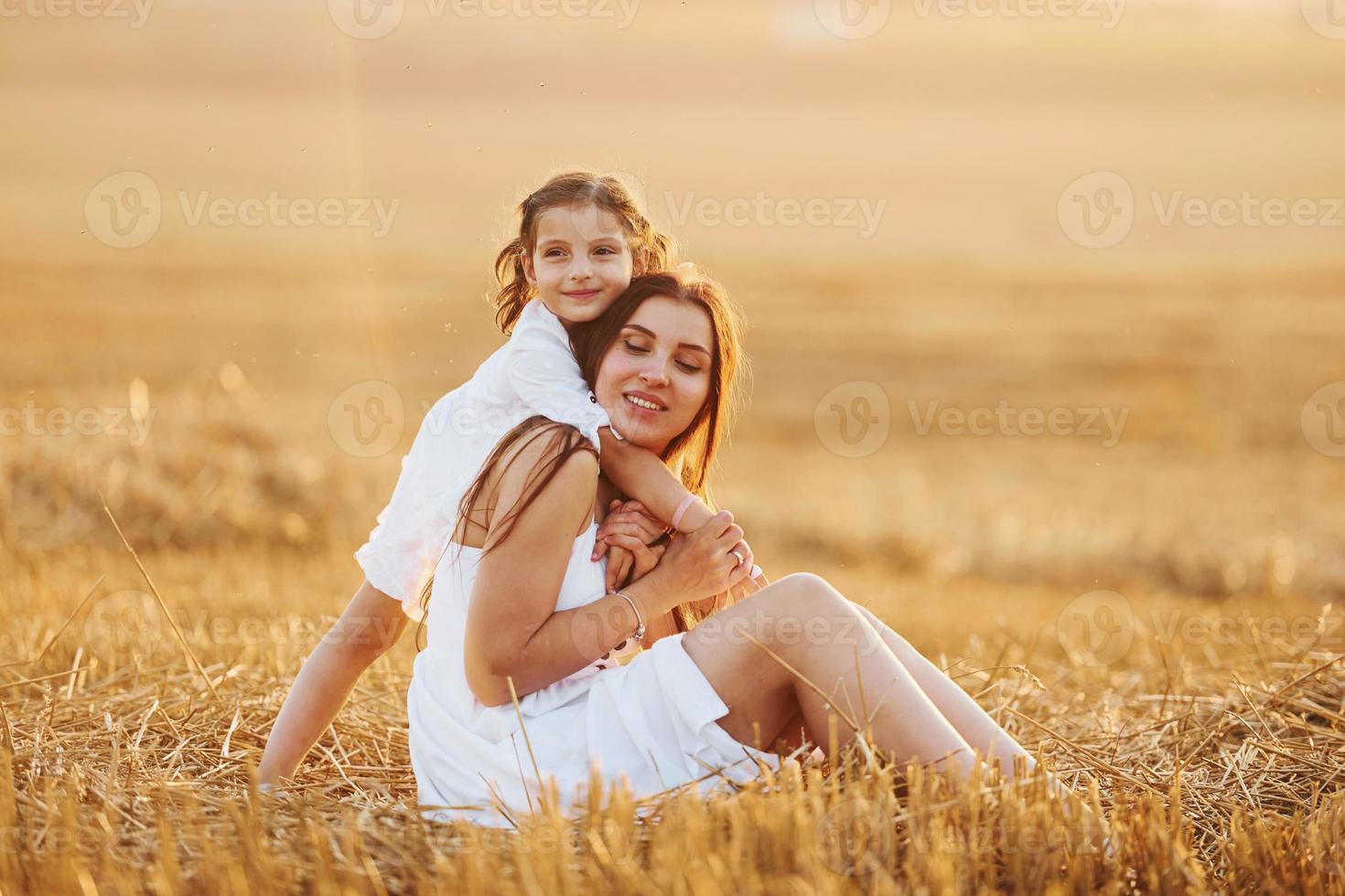 feliz madre con su pequeña hija pasando tiempo juntos al aire libre en el campo foto