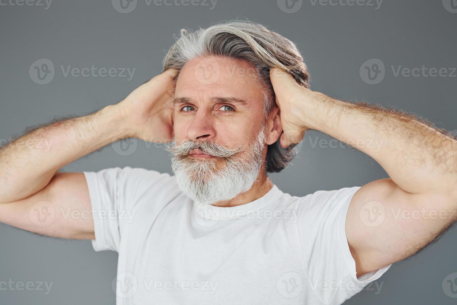 Beautiful portrait. Stylish modern senior man with gray hair and beard is indoors photo