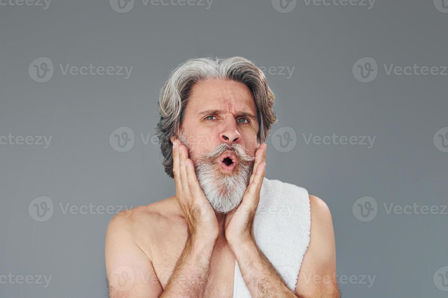 Fresh and clean face. Stylish modern senior man with gray hair and beard is indoors photo