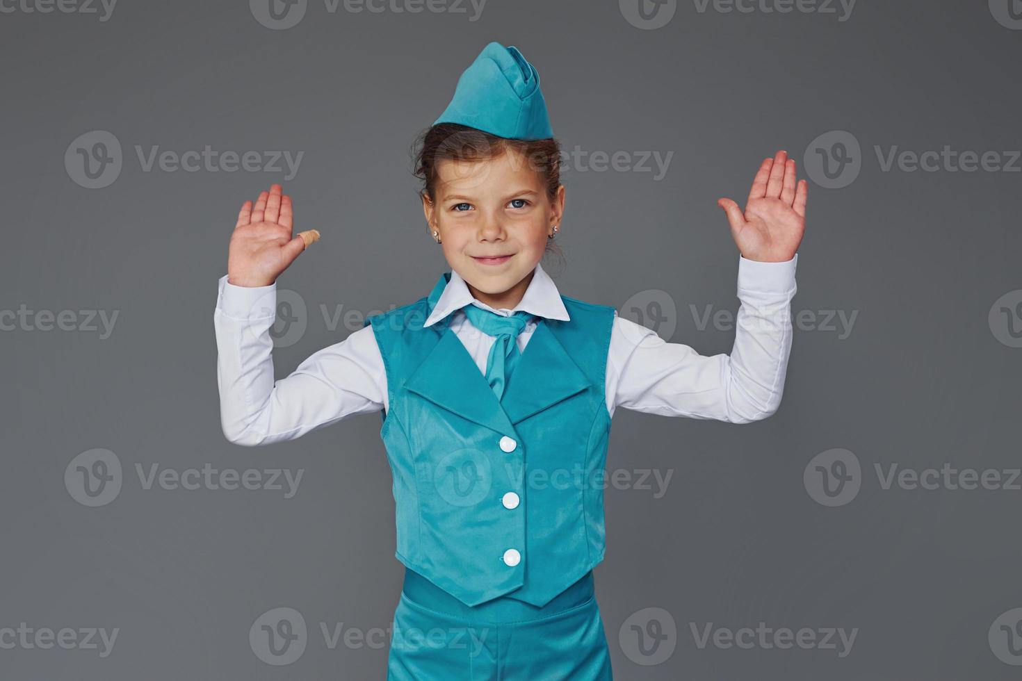 Cute little girl in blue stewardess uniform is posing for the camera photo