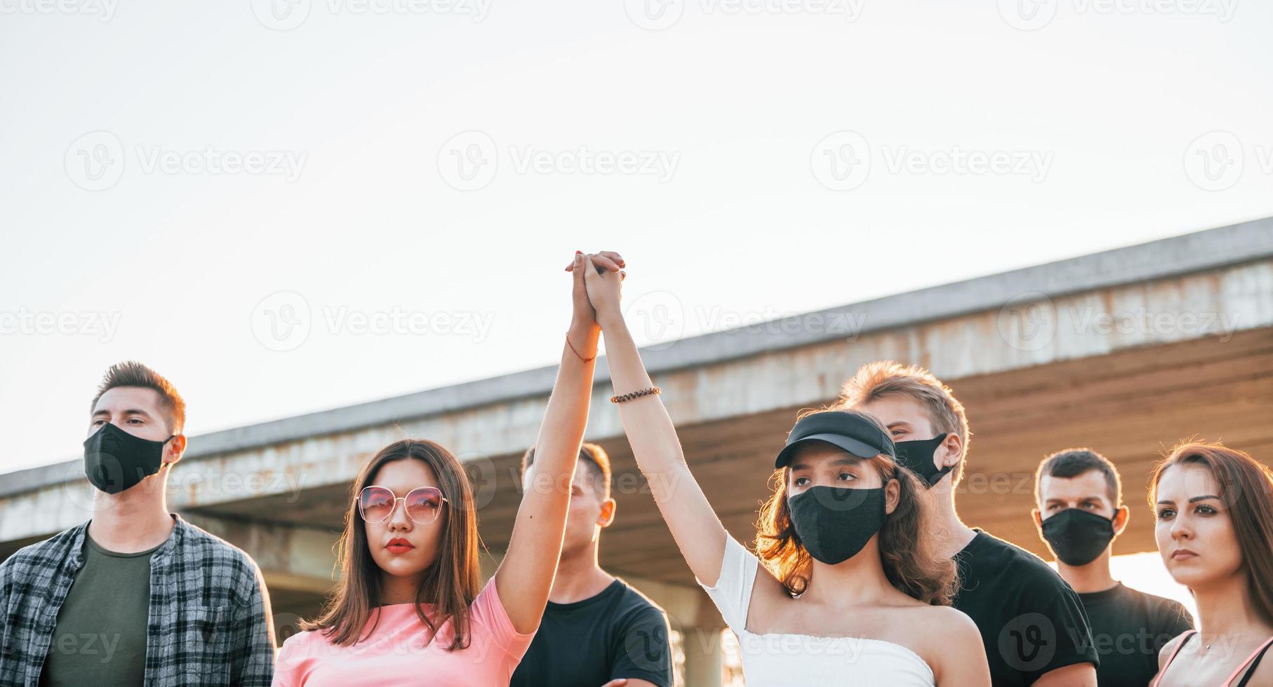 puños en alto. grupo de jóvenes que protestan que se unen. activista por los derechos humanos o contra el gobierno foto