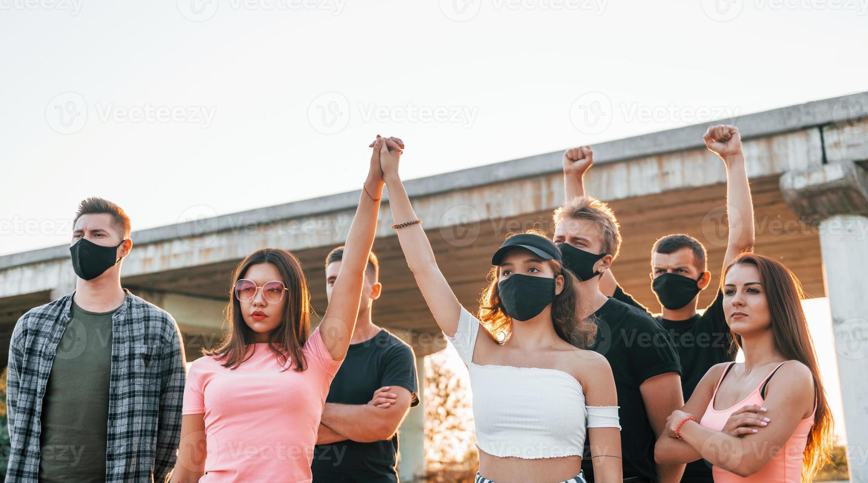 Fists rased high up. Group of protesting young people that standing together. Activist for human rights or against government photo