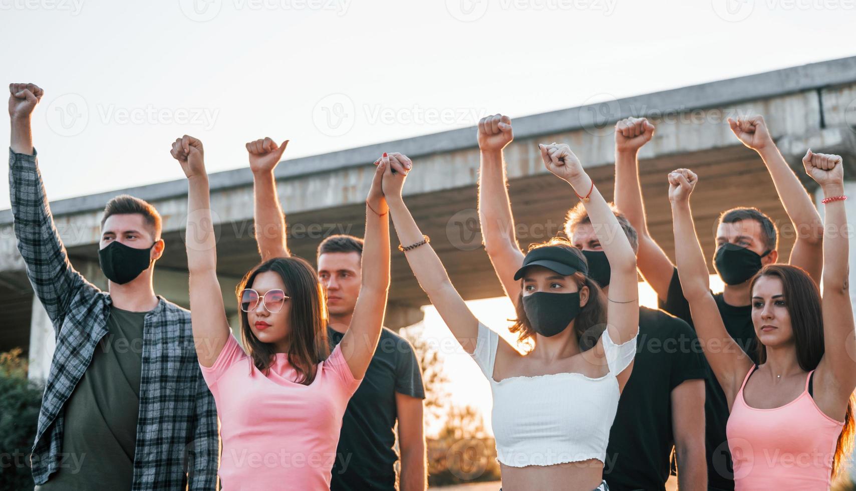 Fists rased high up. Group of protesting young people that standing together. Activist for human rights or against government photo