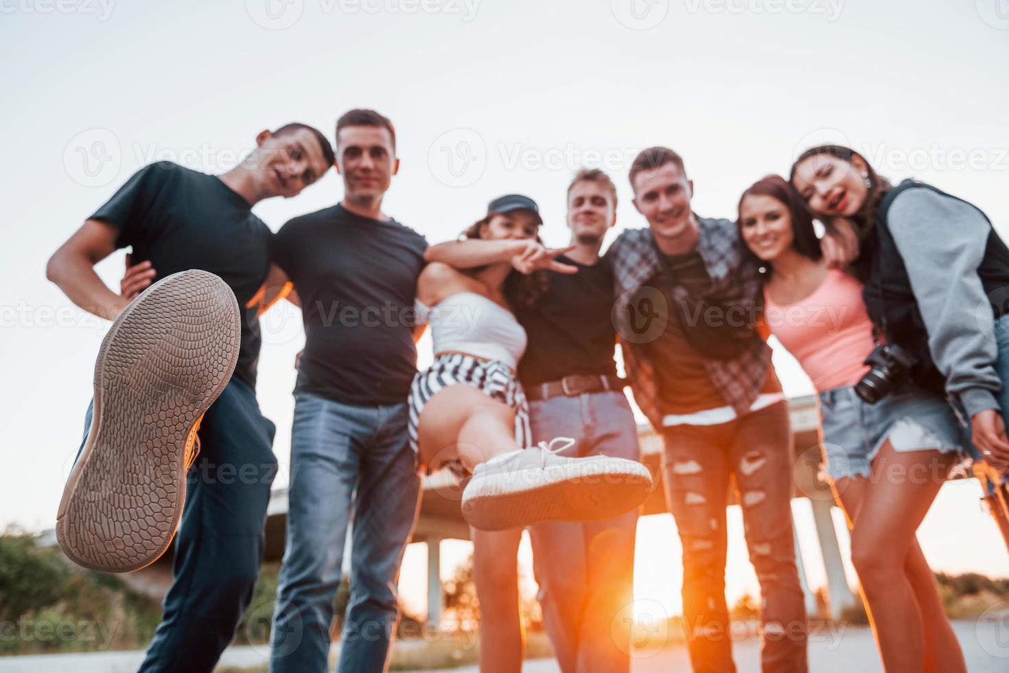 abrazándose unos a otros. grupo de jóvenes amigos alegres divirtiéndose juntos. fiesta al aire libre foto