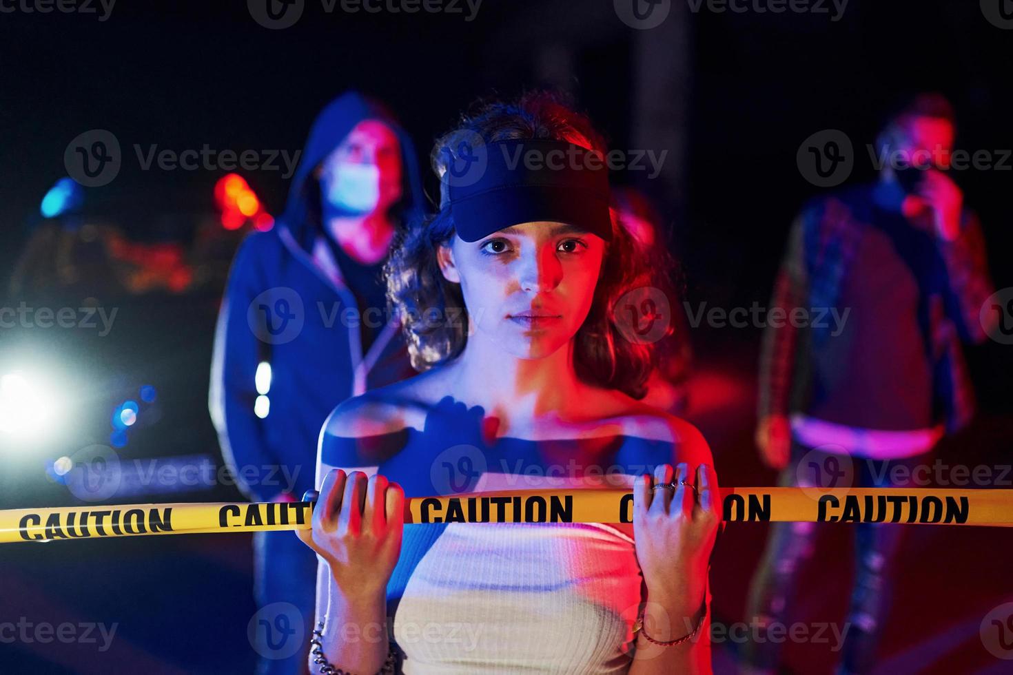 Girl leaning on police tape. Group of protesting young people that standing together. Activist for human rights or against government photo