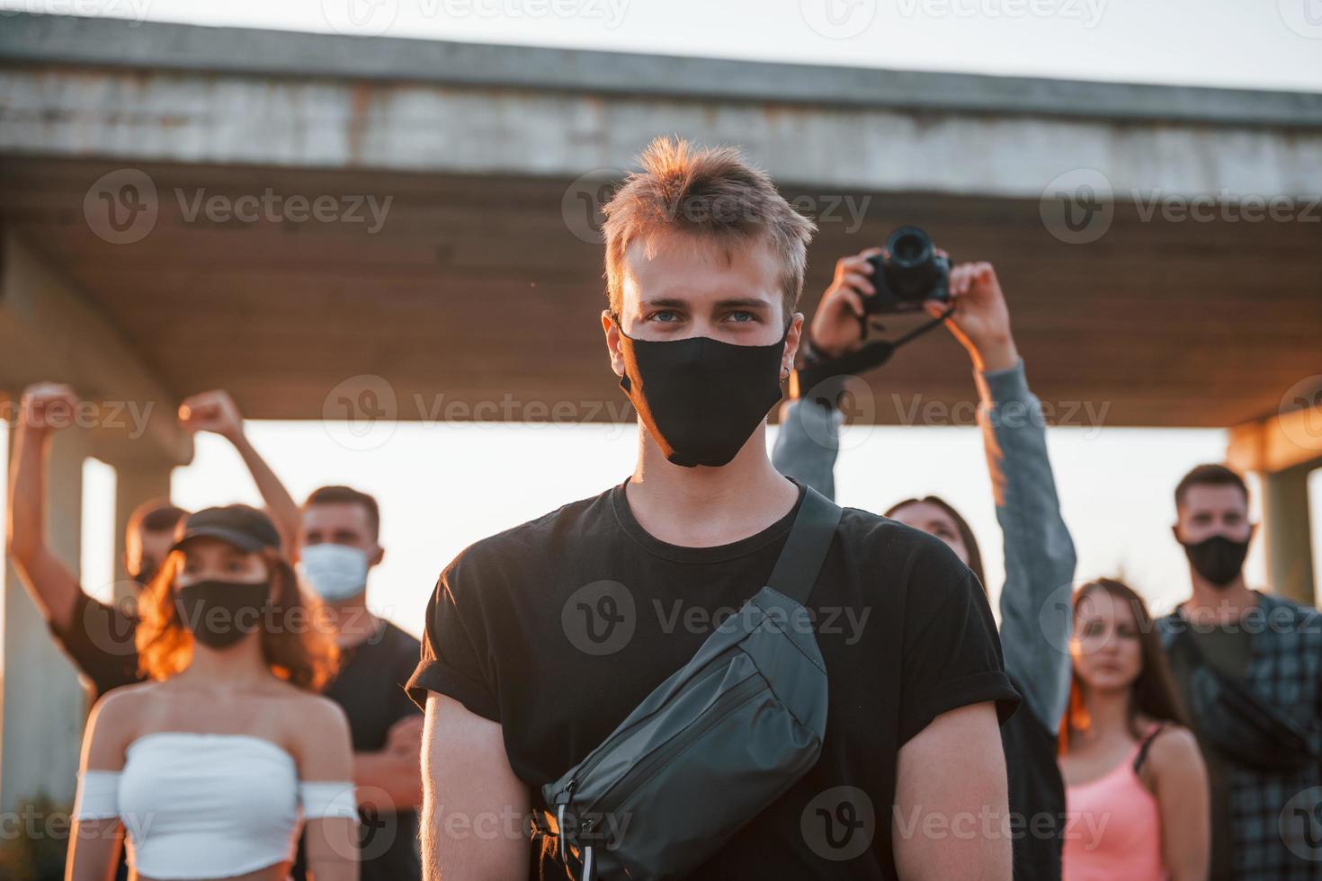 Guy at the front of crowd. Group of protesting young people that standing together. Activist for human rights or against government photo