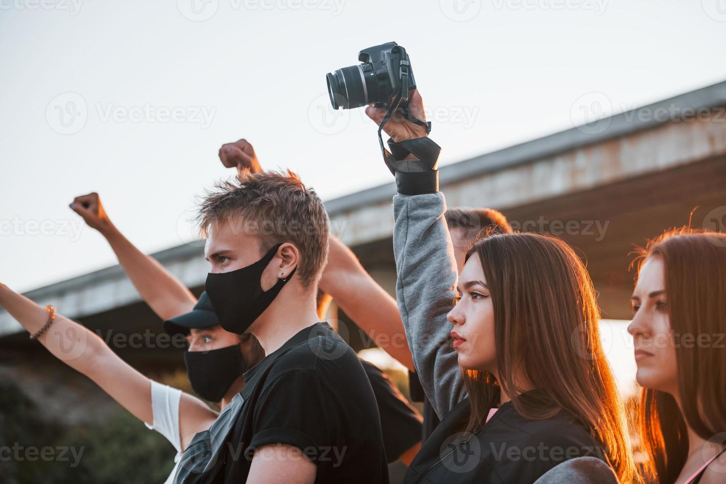 Photographer with camera. Group of protesting young people that standing together. Activist for human rights or against government photo