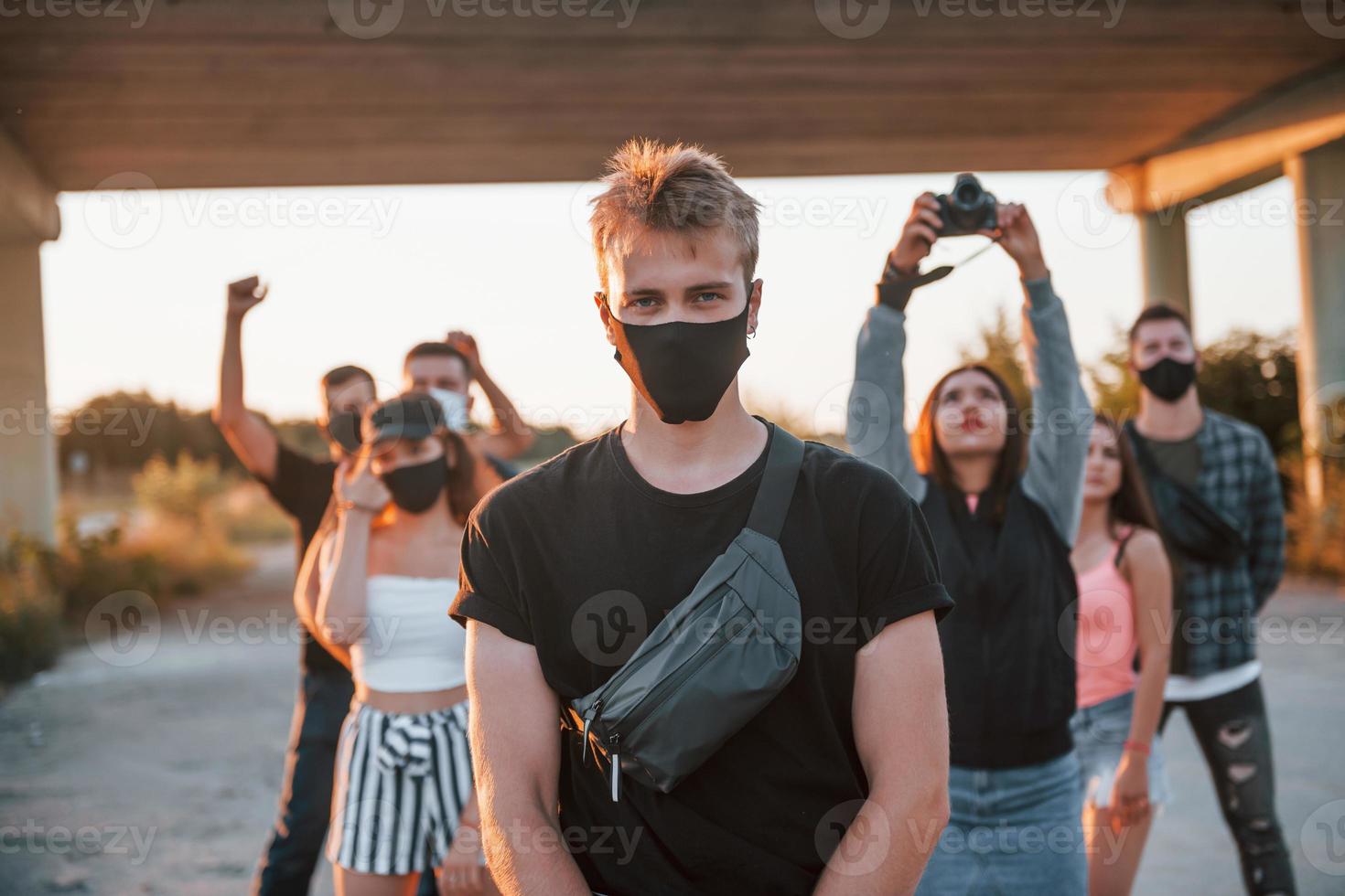 Guy at the front of crowd. Group of protesting young people that standing together. Activist for human rights or against government photo