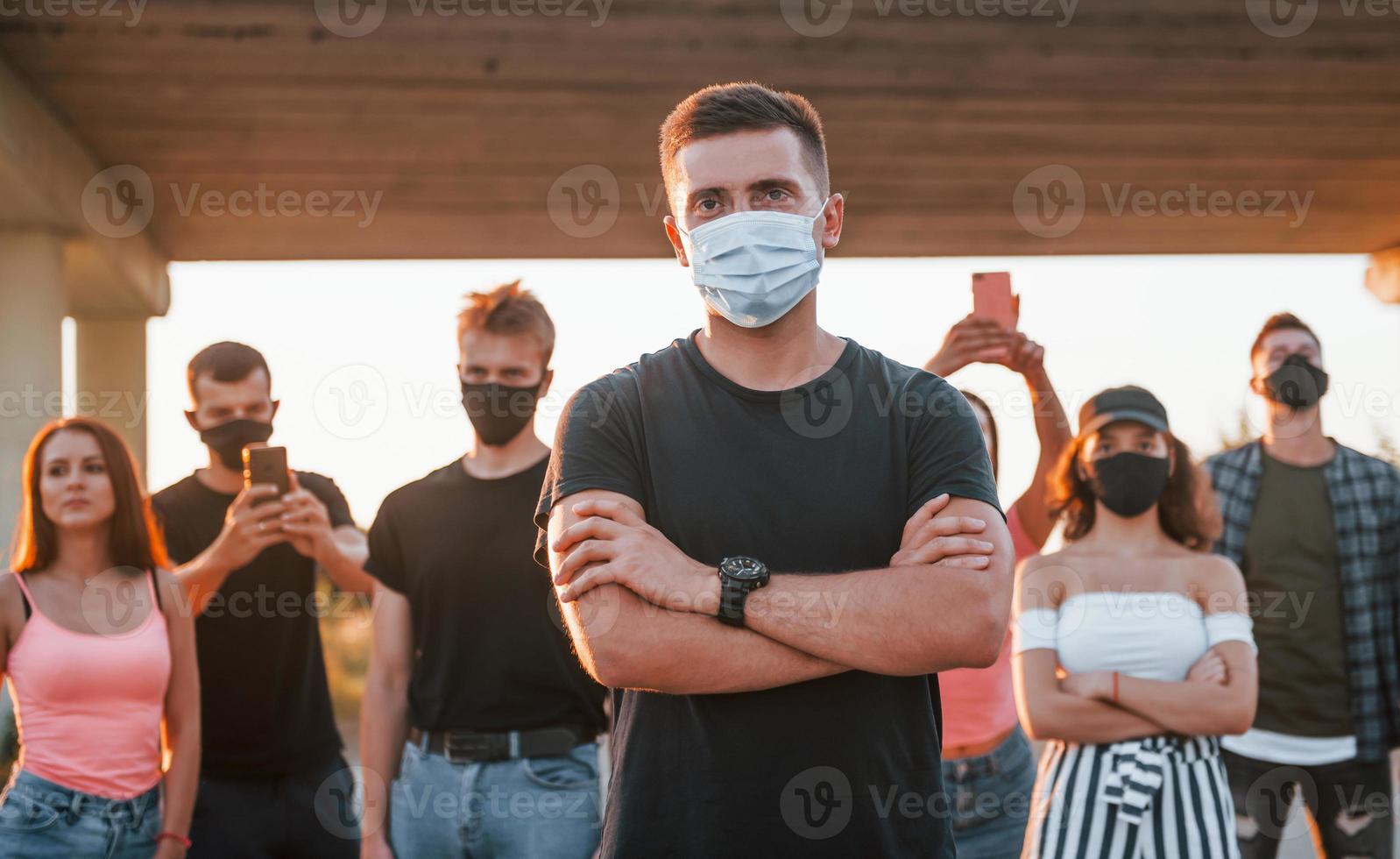 Guy at the front of crowd. Group of protesting young people that standing together. Activist for human rights or against government photo