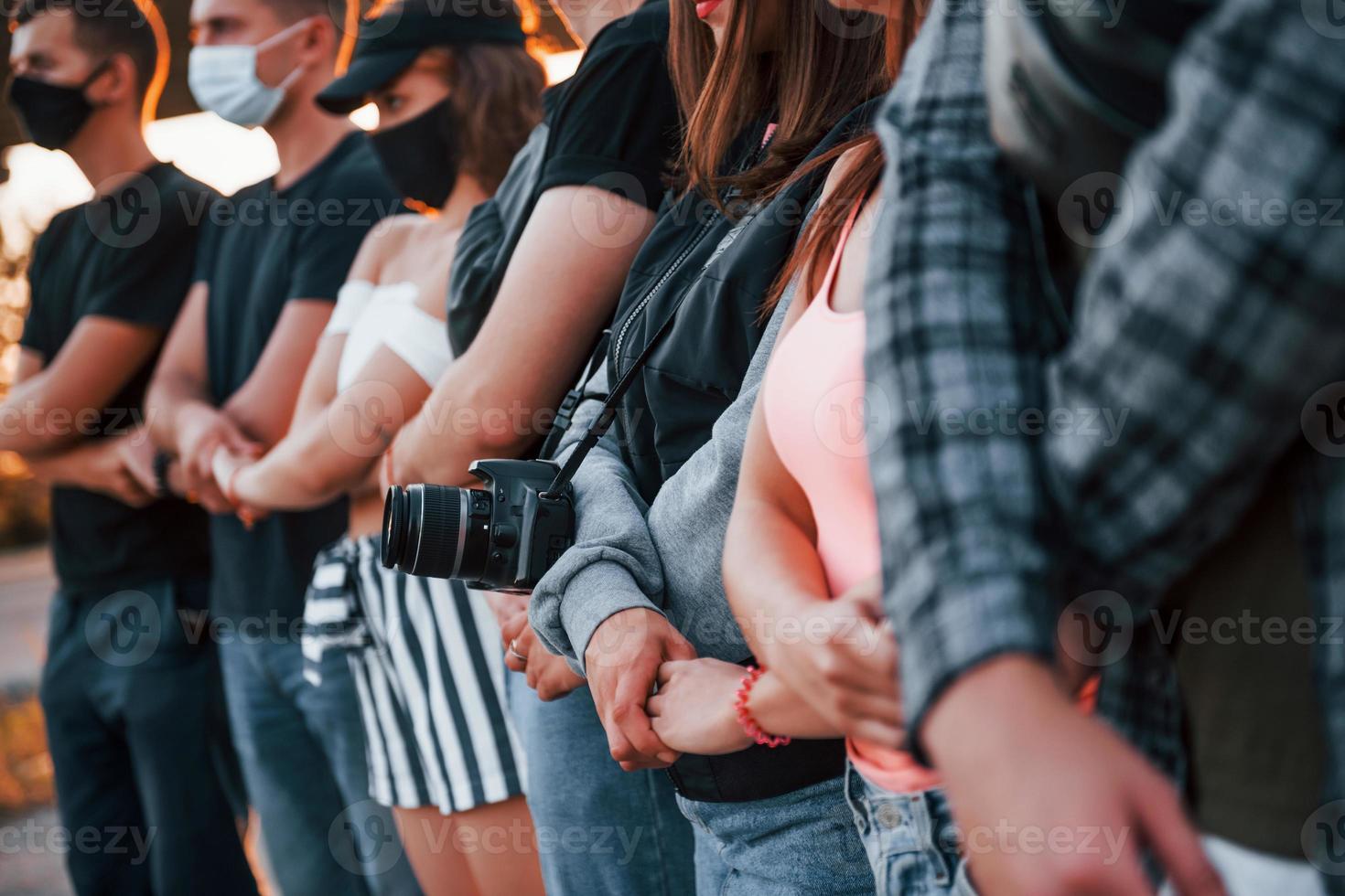 Photographer with camera. Group of protesting young people that standing together. Activist for human rights or against government photo