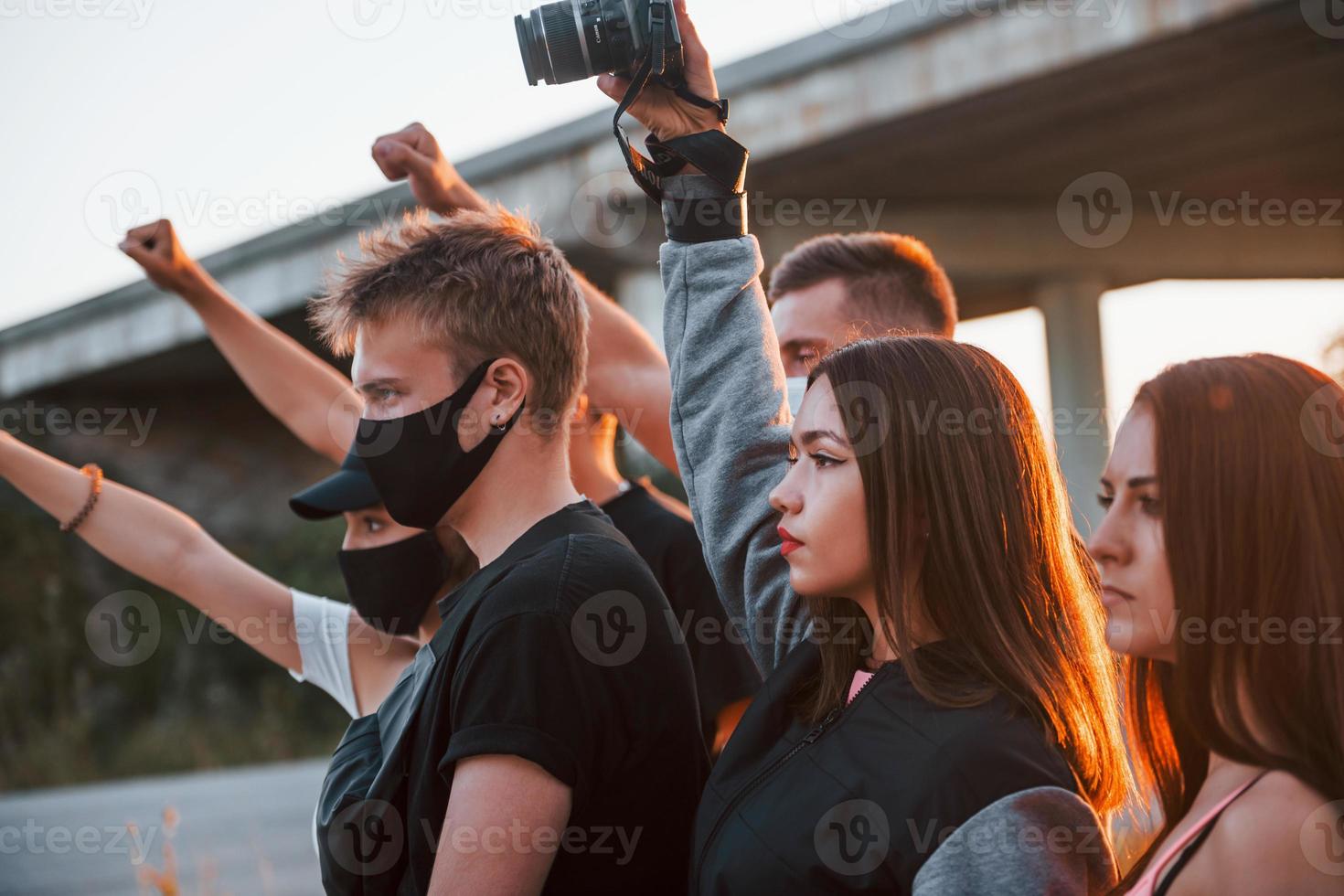 Photographer with camera. Group of protesting young people that standing together. Activist for human rights or against government photo