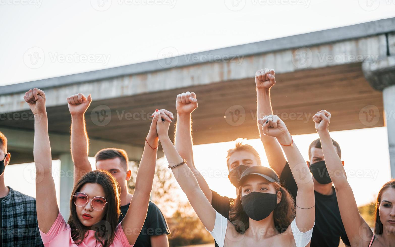 Fists rased high up. Group of protesting young people that standing together. Activist for human rights or against government photo