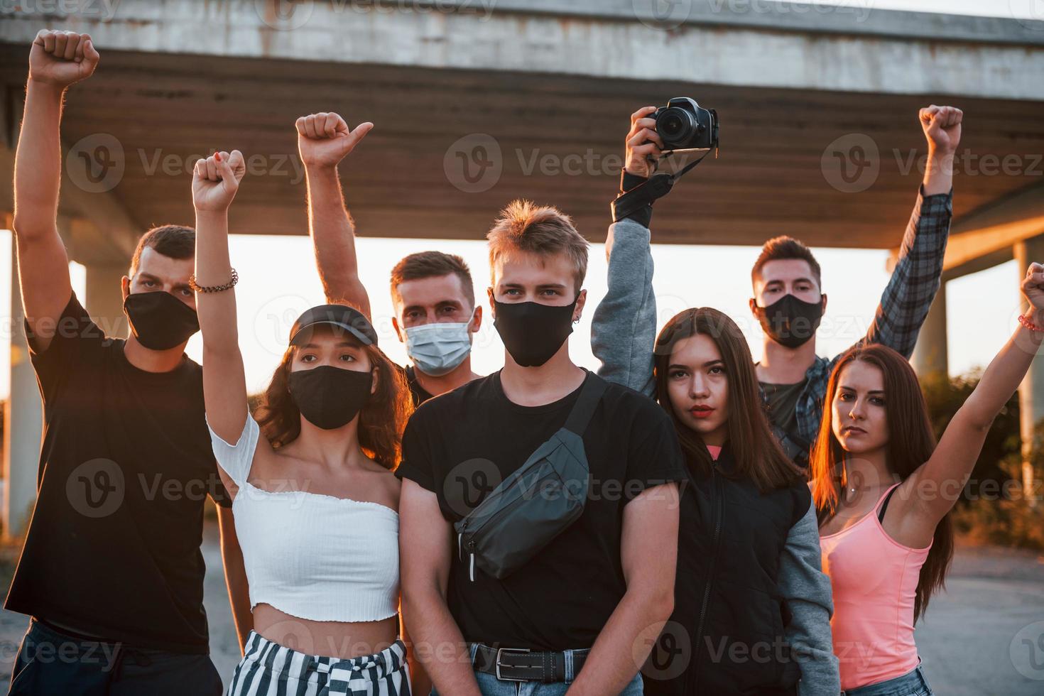 Photographer with camera. Group of protesting young people that standing together. Activist for human rights or against government photo