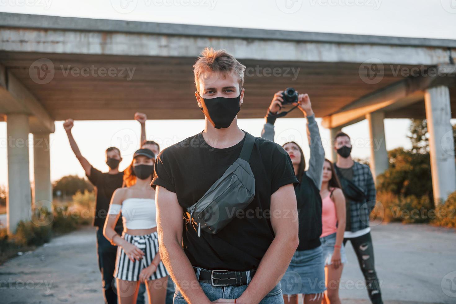 Guy at the front of crowd. Group of protesting young people that standing together. Activist for human rights or against government photo