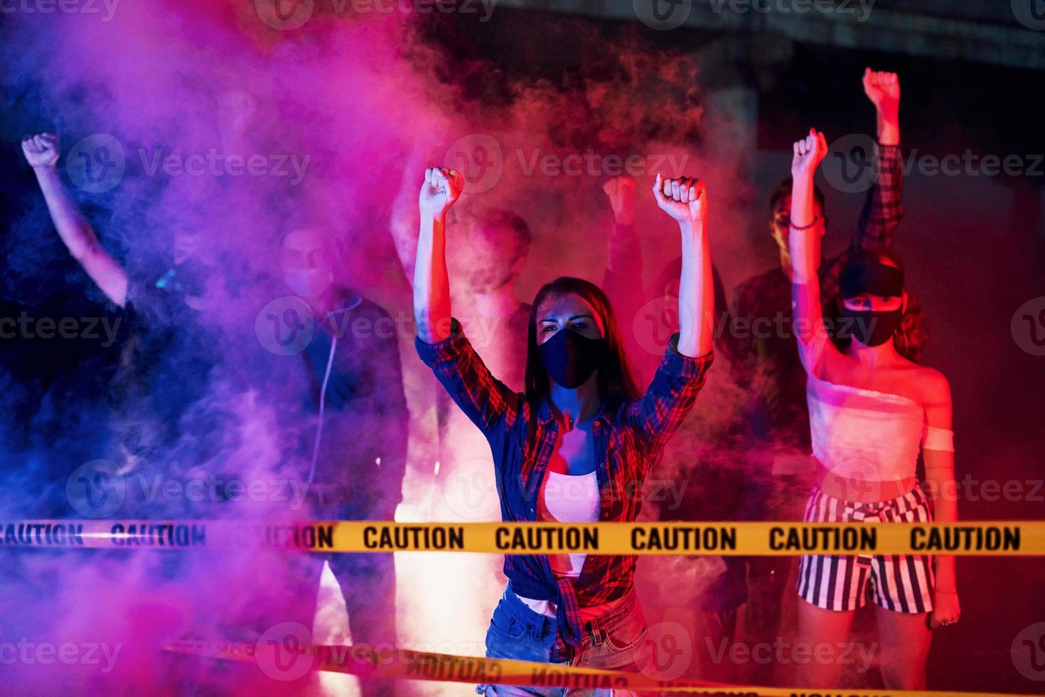 línea de policía y humo. grupo de jóvenes que protestan que se unen. activista por los derechos humanos o contra el gobierno foto