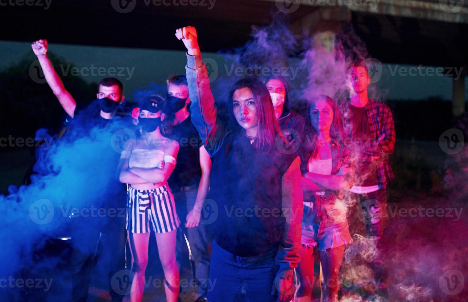 Smoke, fists, police. Group of protesting young people that standing together. Activist for human rights or against government photo