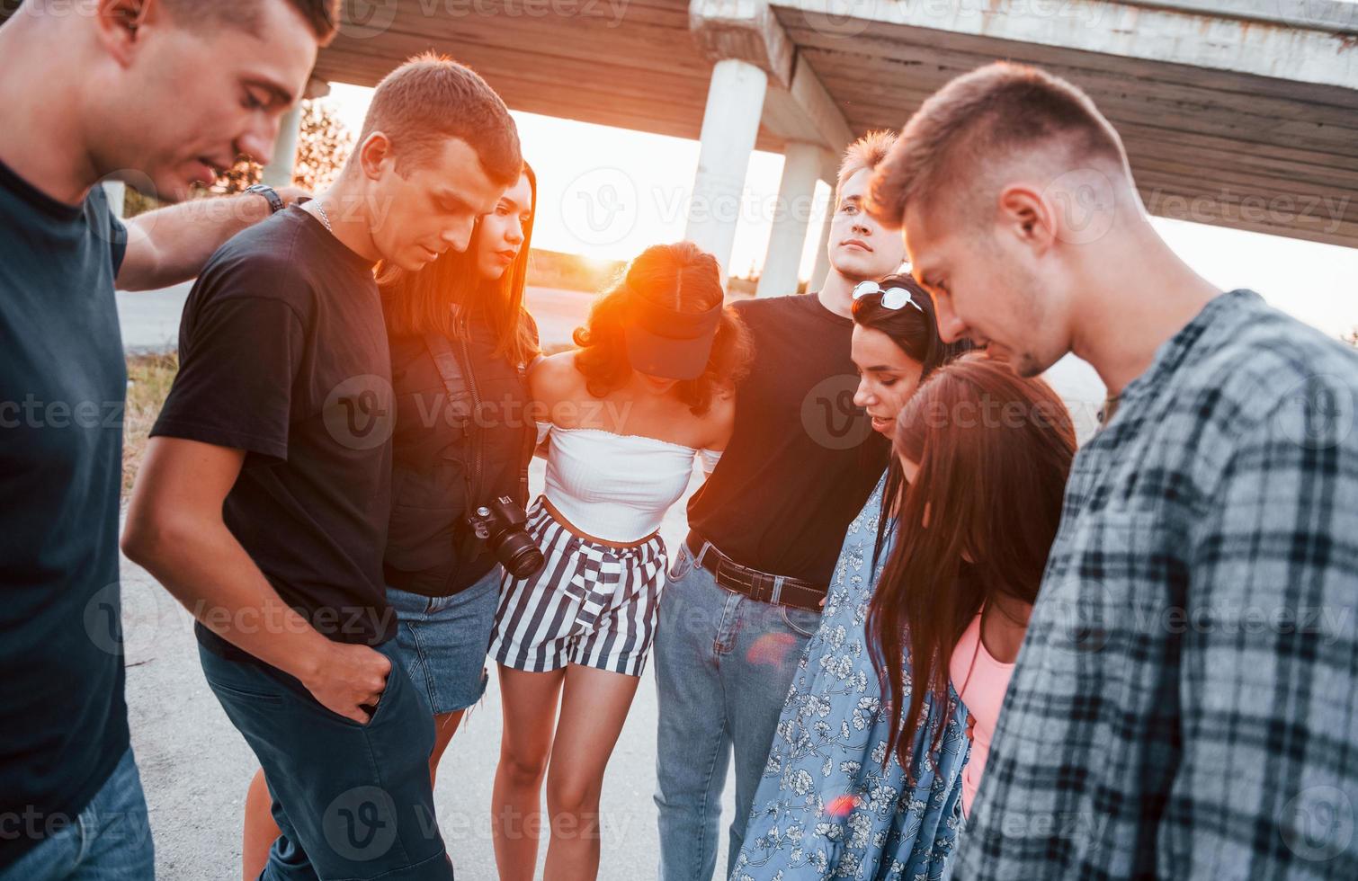 hablando y riendo. grupo de jóvenes amigos alegres divirtiéndose juntos. fiesta al aire libre foto