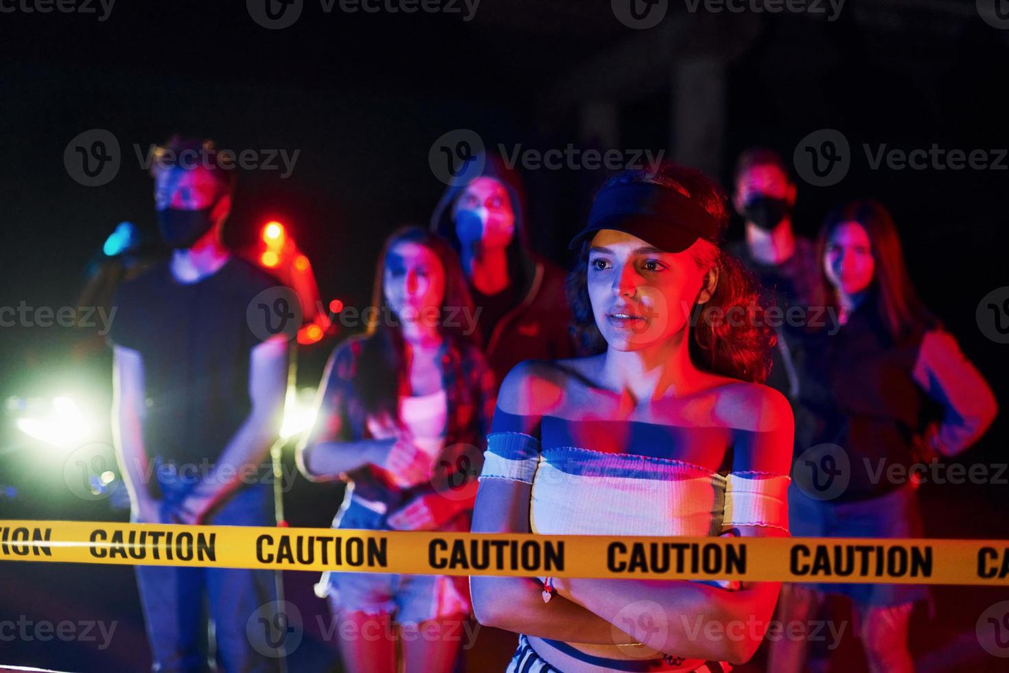 Calm woman standing in front of crowd. Group of protesting young people that standing together. Activist for human rights or against government photo
