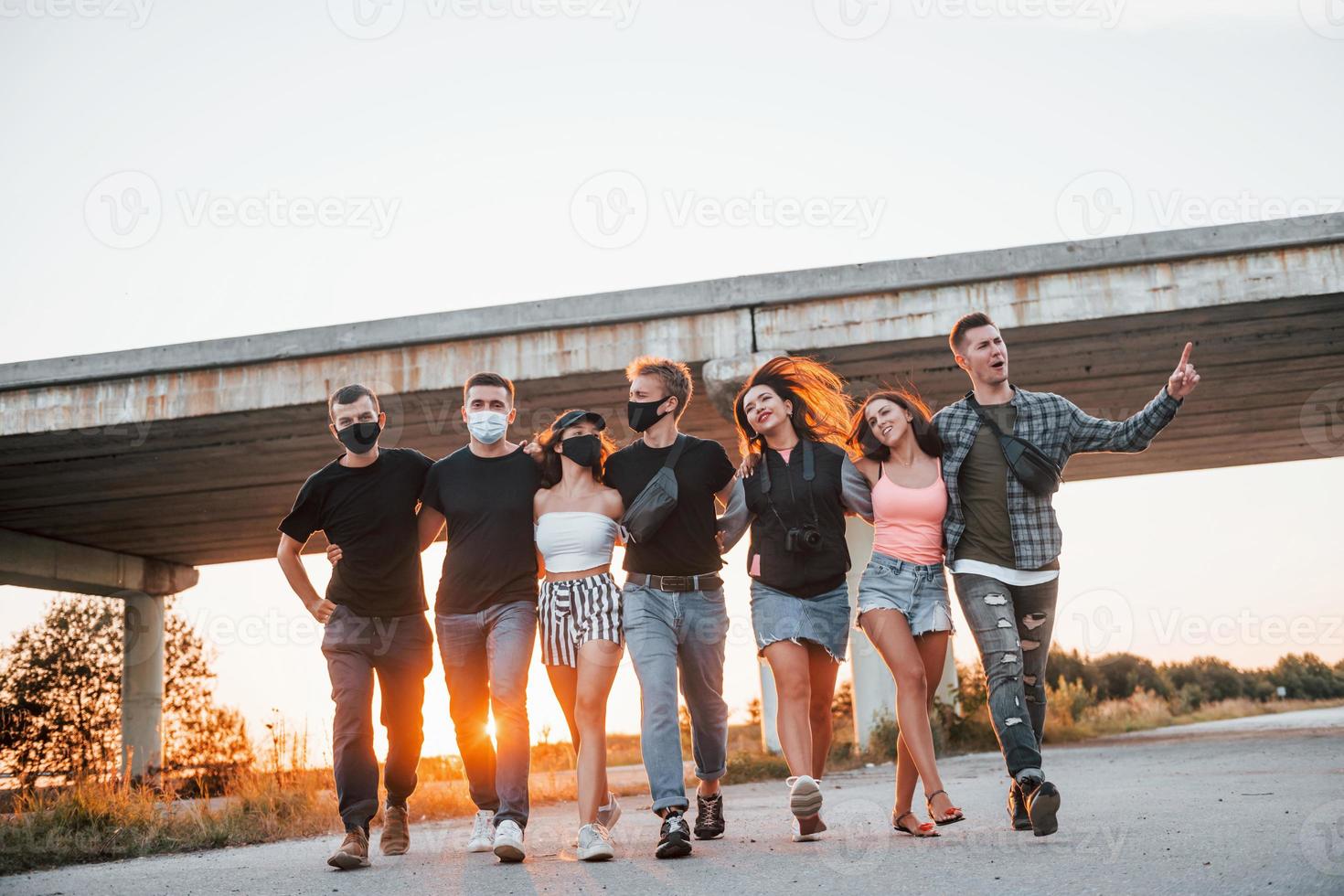 Embracing each other. Group of young cheerful friends having fun together. Party outdoors photo