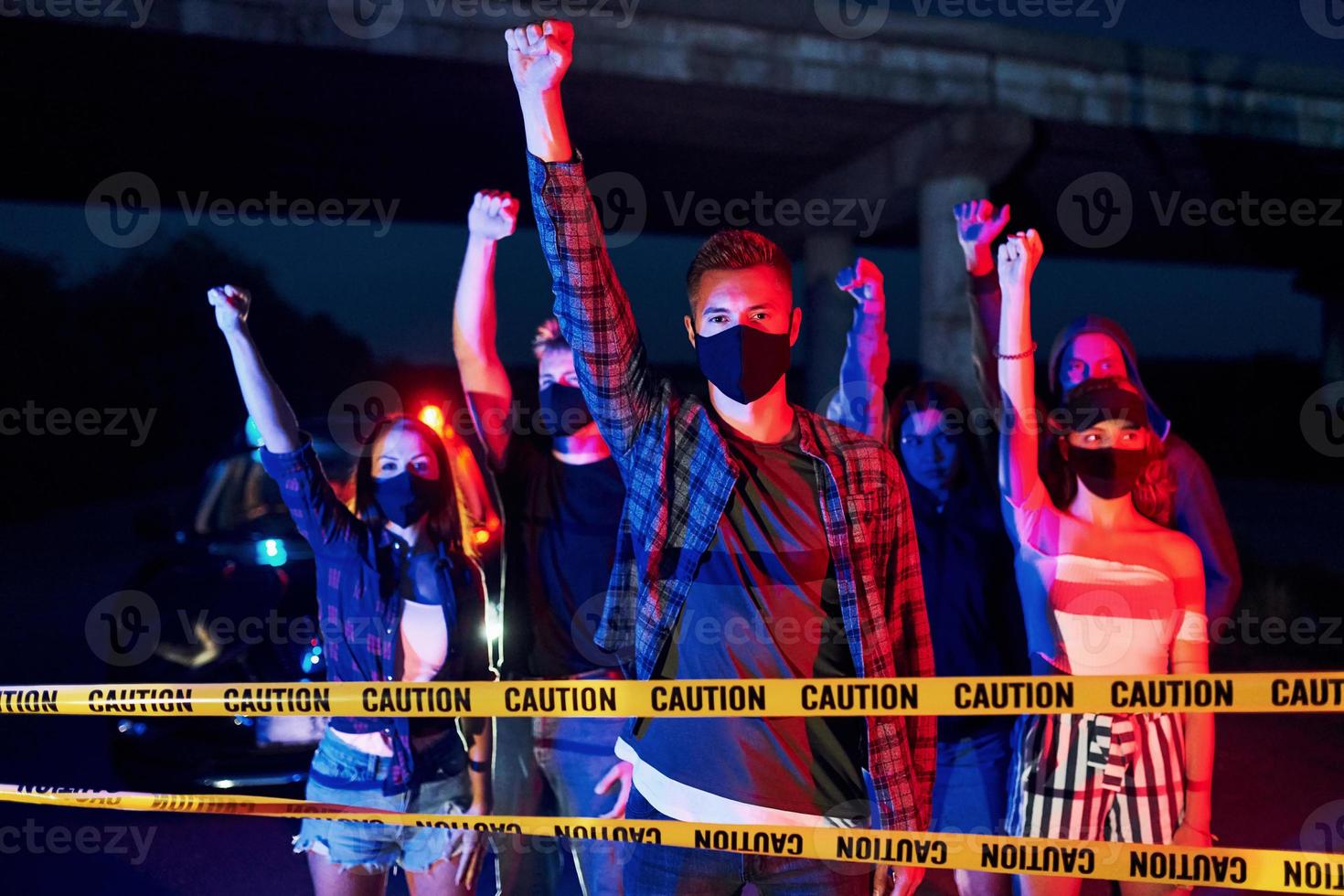 iluminación policial roja y azul. grupo de jóvenes que protestan que se unen. activista por los derechos humanos o contra el gobierno foto