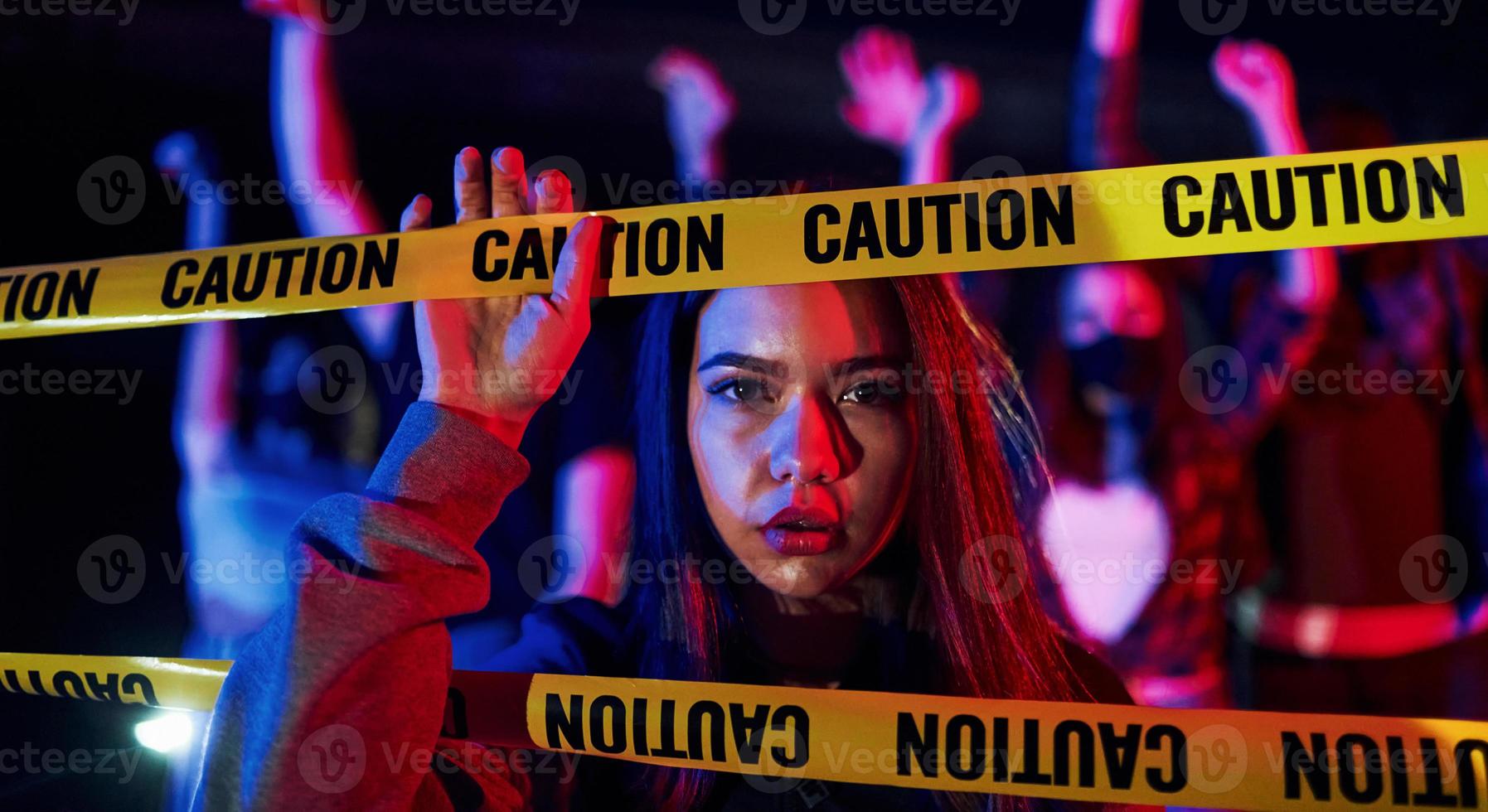 Beautiful woman near police border line. Group of protesting young people that standing together. Activist for human rights or against government photo