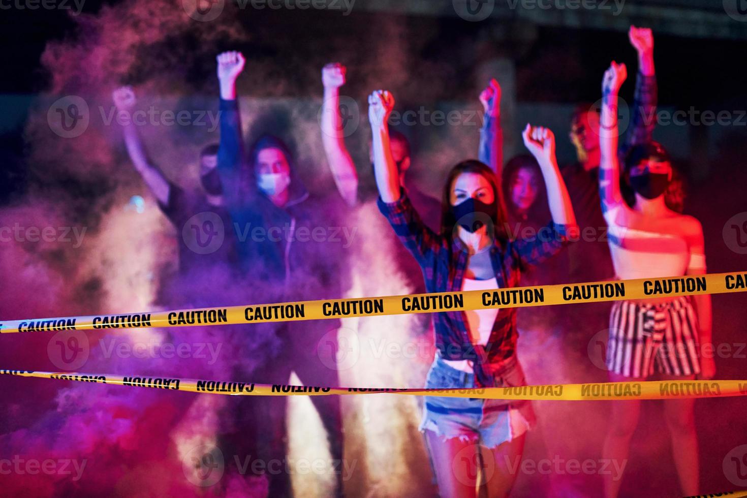 Police line and smoke. Group of protesting young people that standing together. Activist for human rights or against government photo