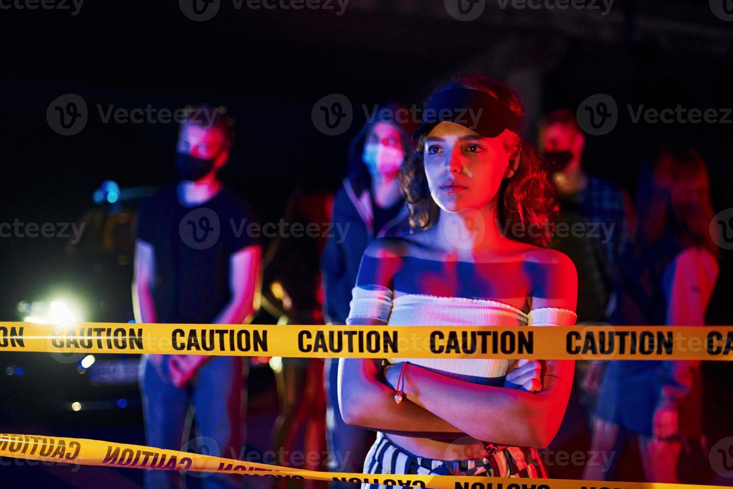 Calm woman standing in front of crowd. Group of protesting young people that standing together. Activist for human rights or against government photo