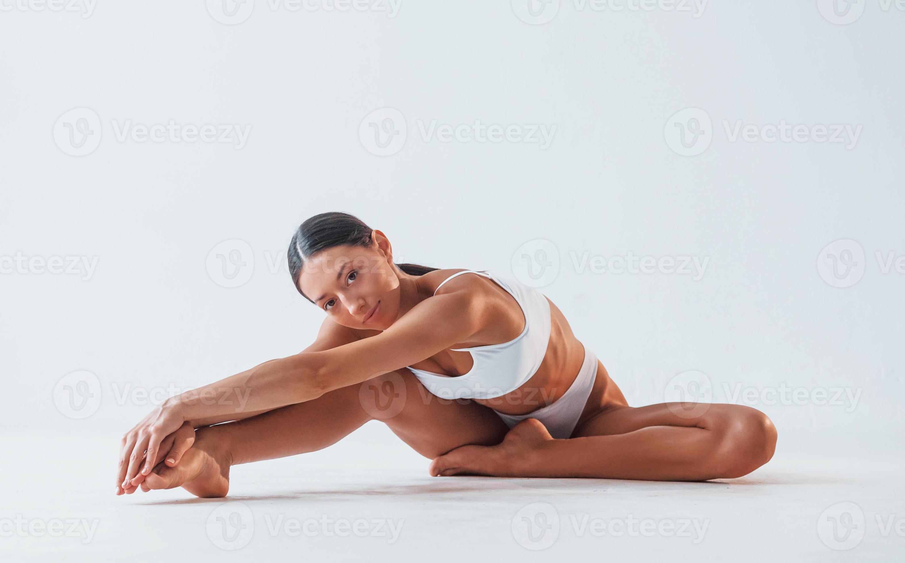 Doing yoga exercises. Woman with sportive slim body type in underwear that  is in the studio 15302733 Stock Photo at Vecteezy