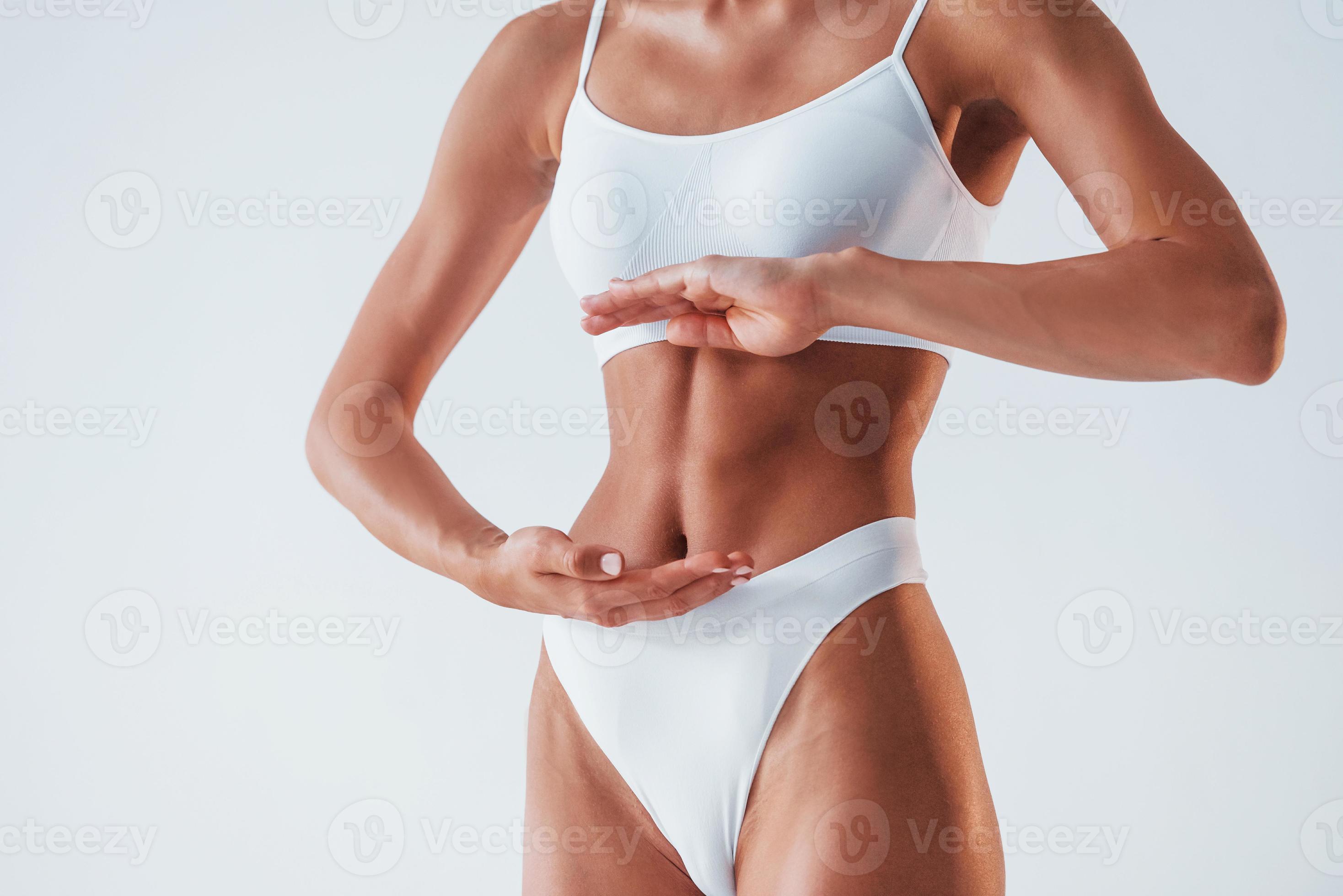 Close up view of stomach. Beautiful woman with slim body in underwear is in  the studio 15301669 Stock Photo at Vecteezy
