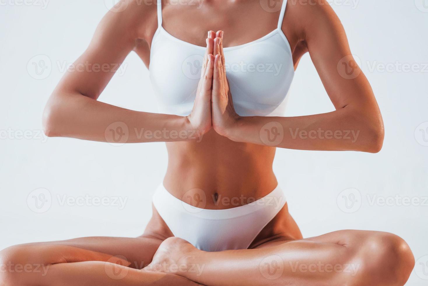 Doing exercises for the spine. Young woman in underwear is in the studio  Stock Photo by mstandret