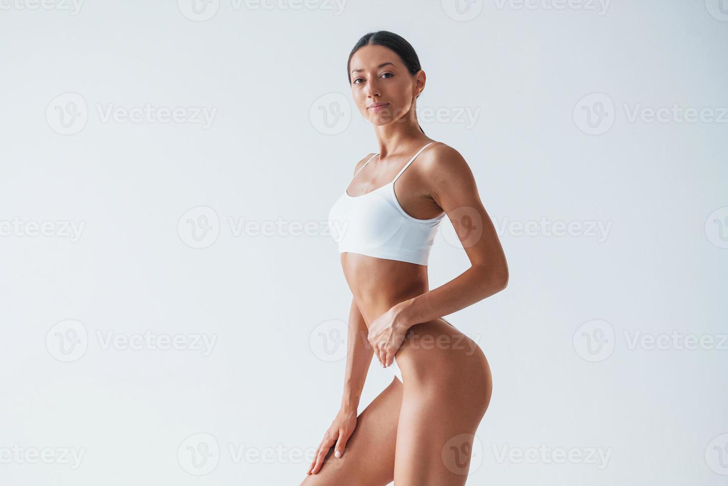 Posing for a camera. Beautiful woman with slim body in underwear is in the studio photo