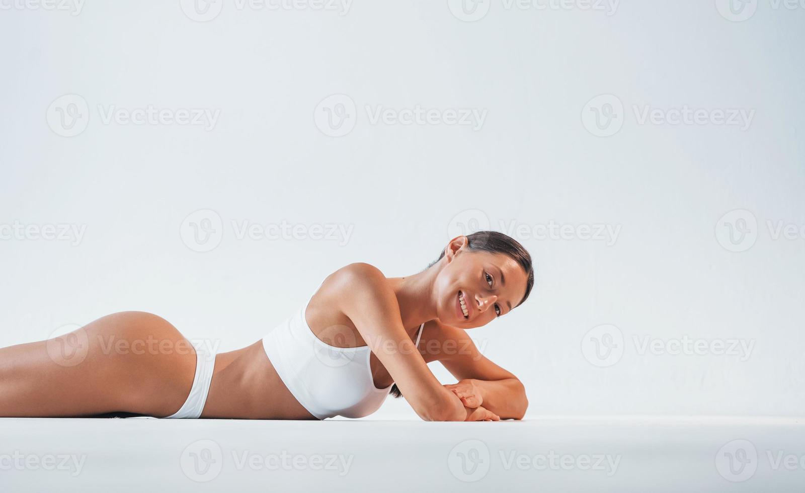 tumbado en el suelo. hermosa mujer con cuerpo delgado en ropa interior está  en el estudio 15301706 Foto de stock en Vecteezy