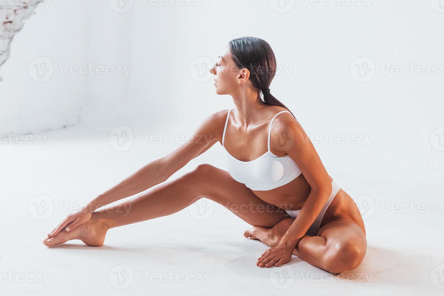 Doing yoga exercises. Woman with sportive slim body type in underwear that  is in the studio 15302733 Stock Photo at Vecteezy