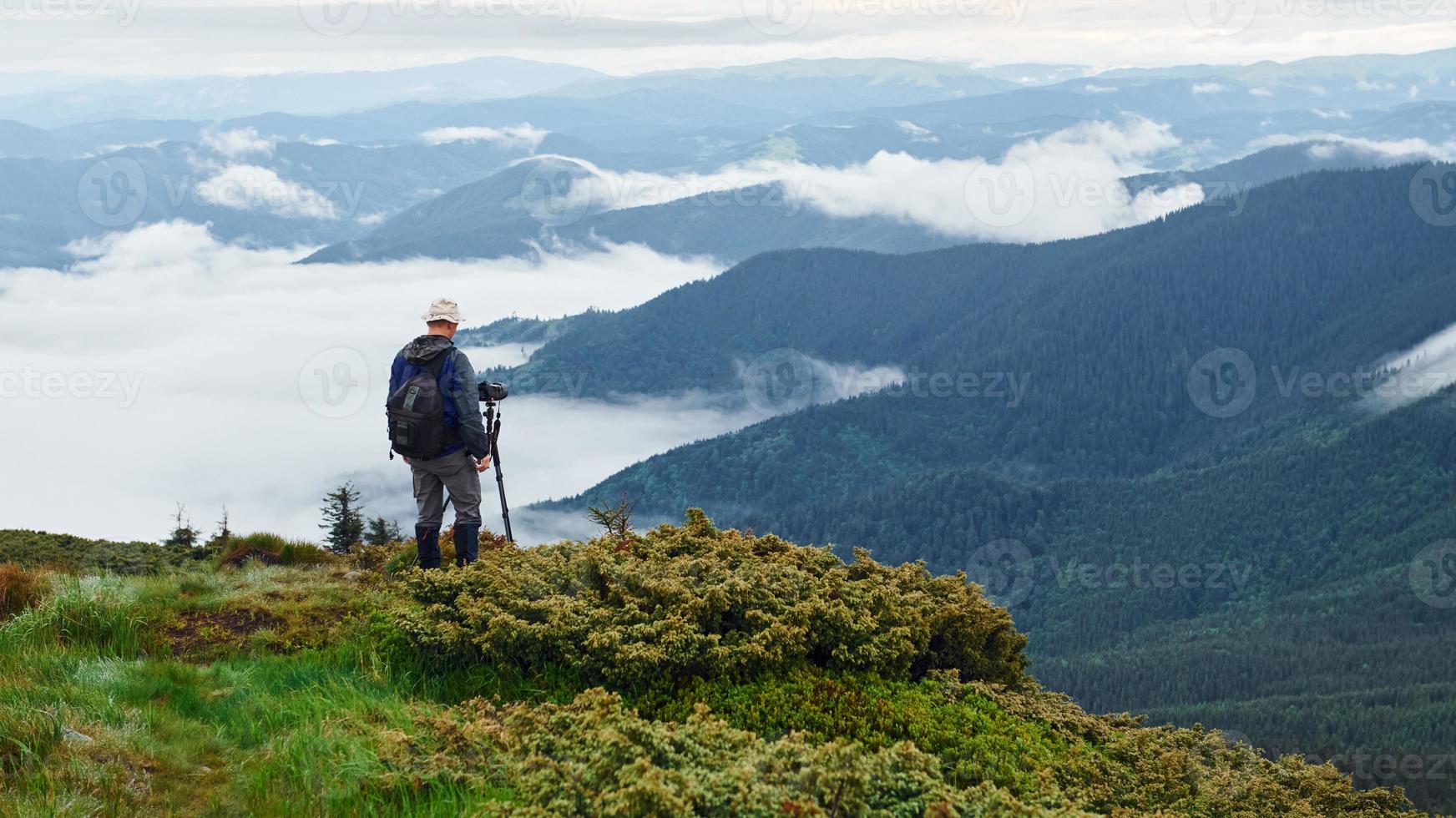 Professional photographer works with camera on tripod. Majestic Carpathian Mountains. Beautiful landscape of untouched nature photo