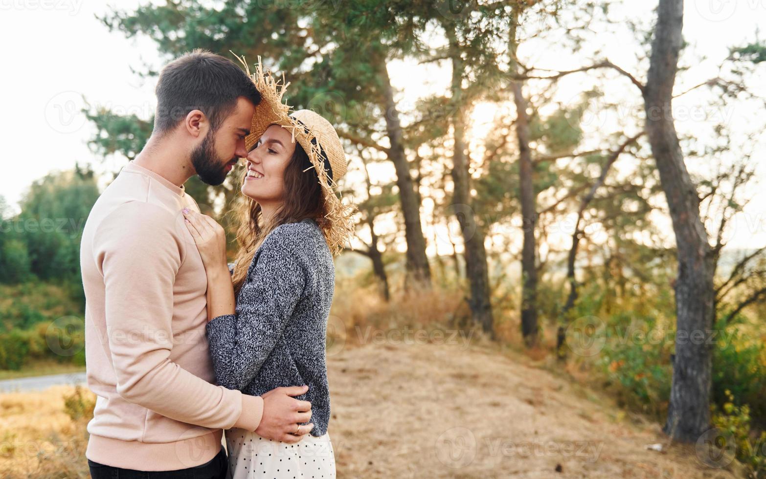 Standing and hugging. Cheerful lovely young couple having a rest outdoors together photo