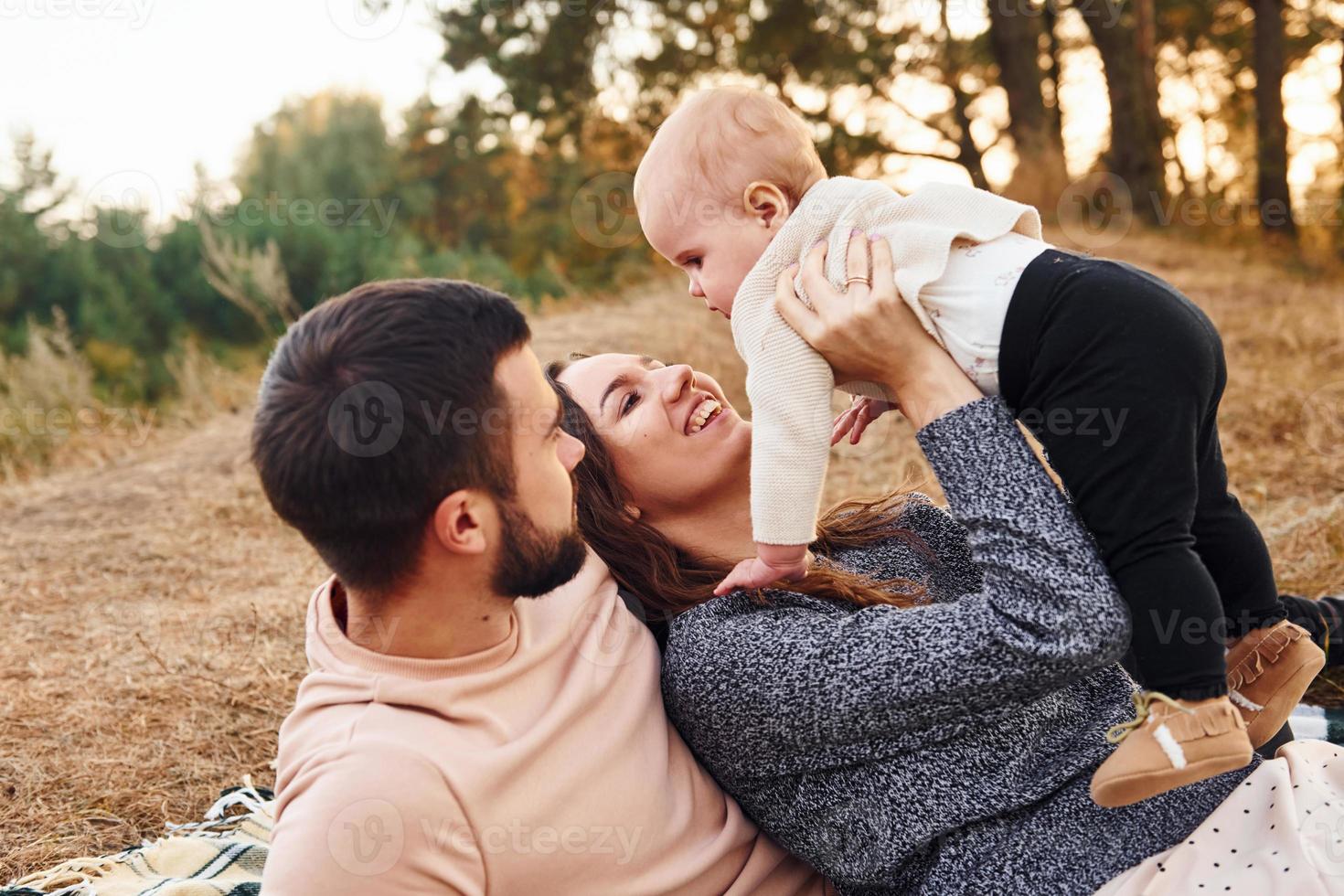 tiene picnic. feliz familia de madre, familia y bebé descansa al aire libre. hermosa naturaleza soleada de otoño foto