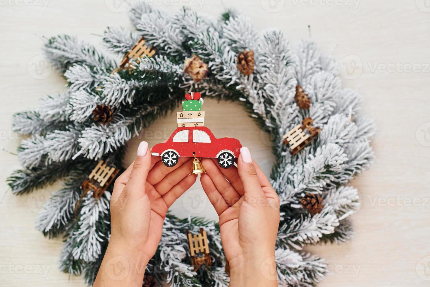 Woman's hands holds toys. Top view of christmas festive texture with new year decorations photo