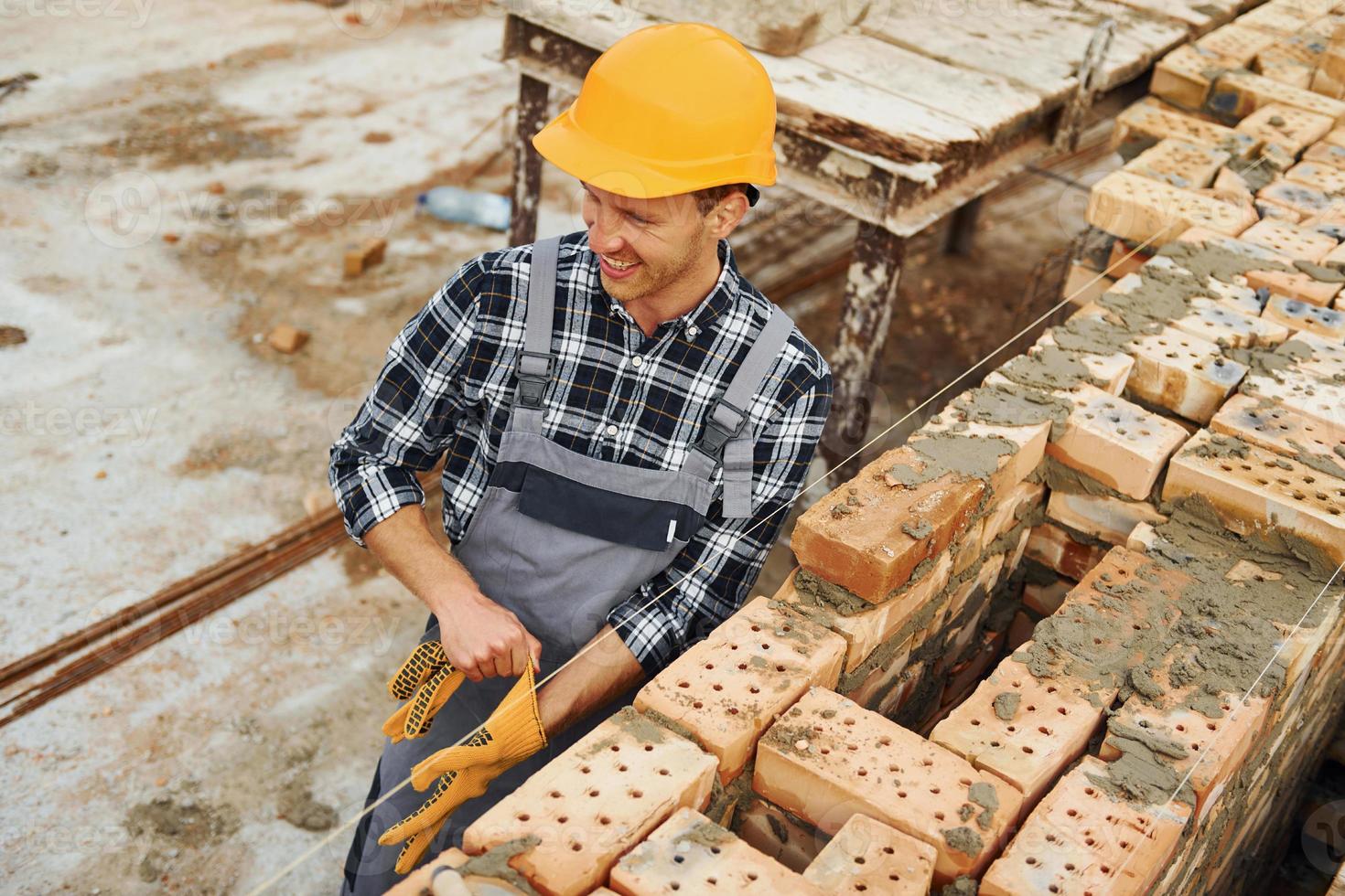 Construction worker in uniform and safety equipment have job on building photo