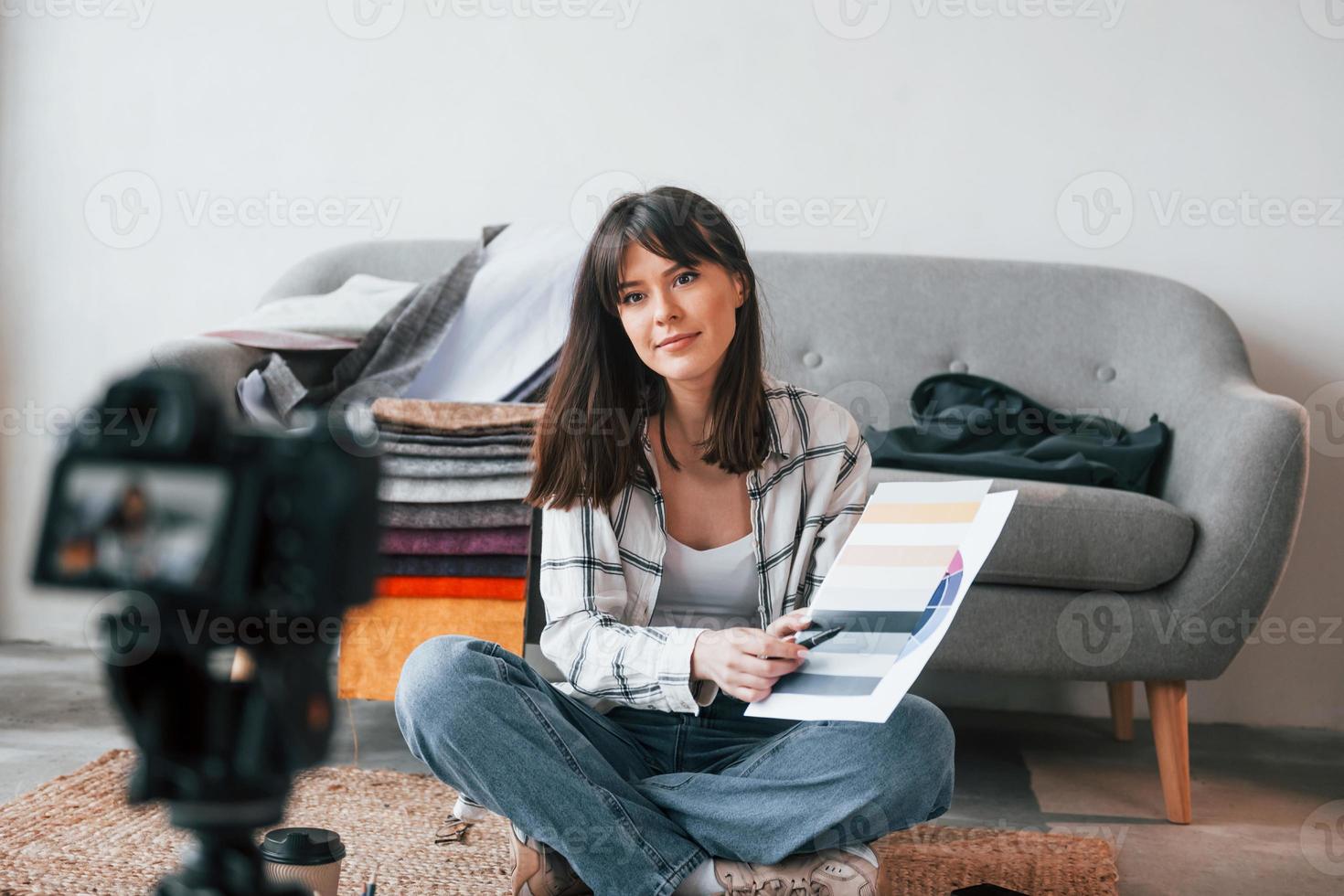 Camera is on the floor. Young female freelance worker is indoors in home at daytime photo
