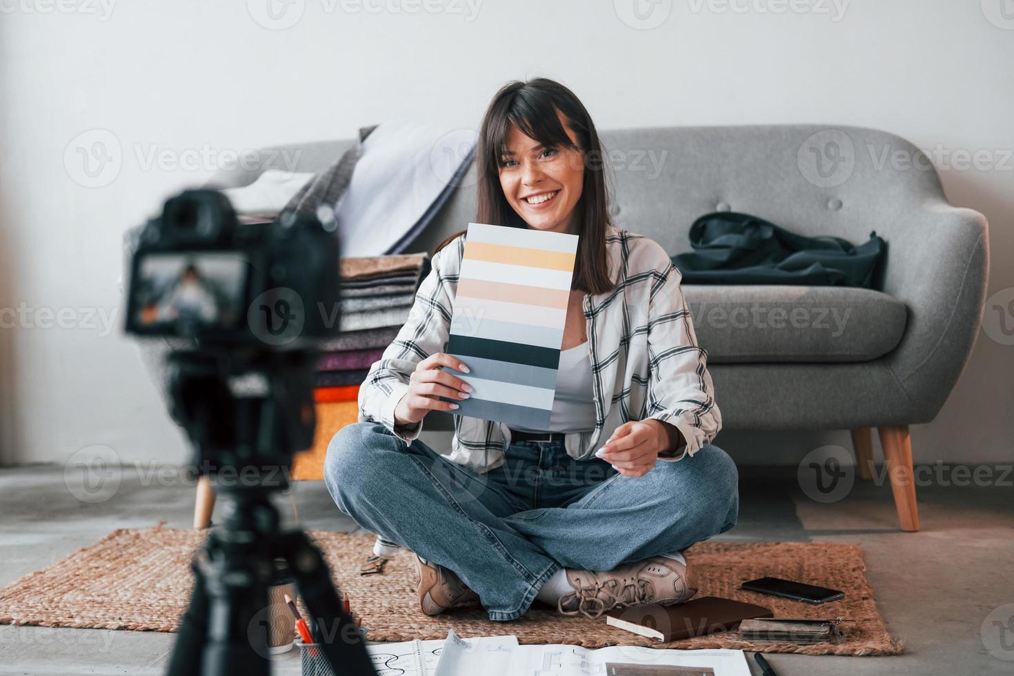 Camera is on the floor. Young female freelance worker is indoors in home at daytime photo