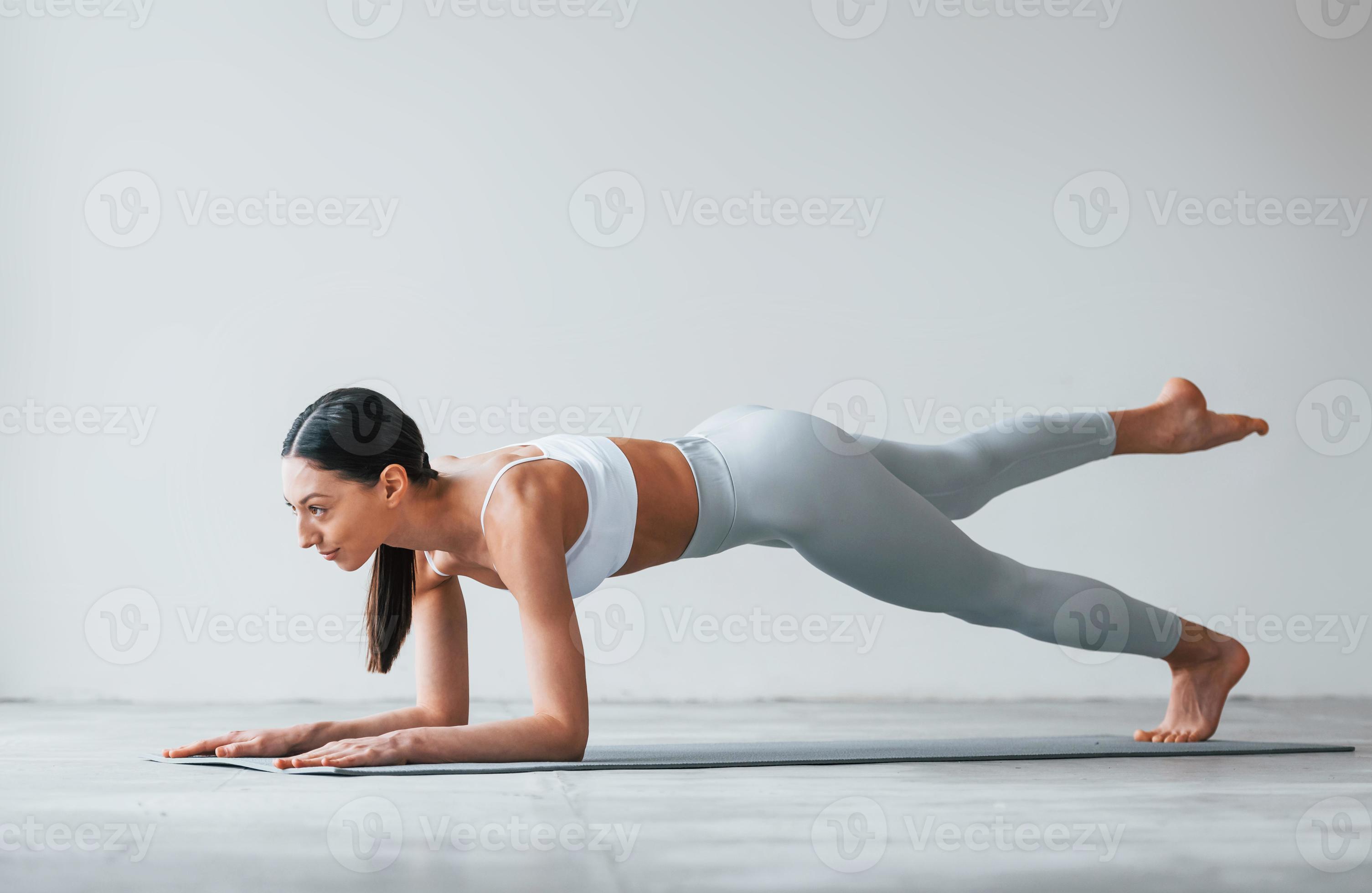 Doing yoga exercises. Woman with sportive slim body type in underwear that  is in the studio 15303041 Stock Photo at Vecteezy