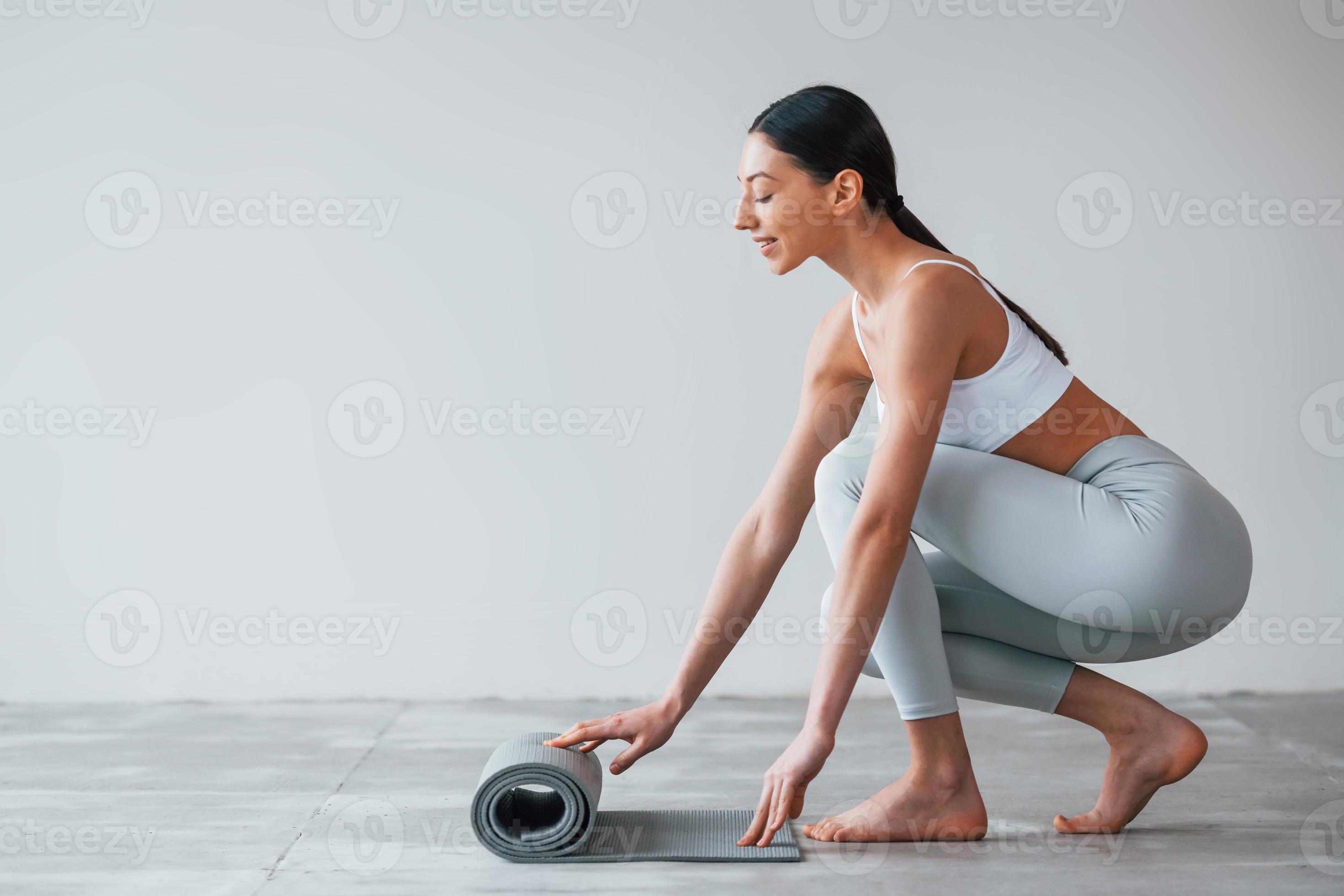 With yoga mat. Woman with sportive slim body type in underwear that is in  the studio 15303058 Stock Photo at Vecteezy