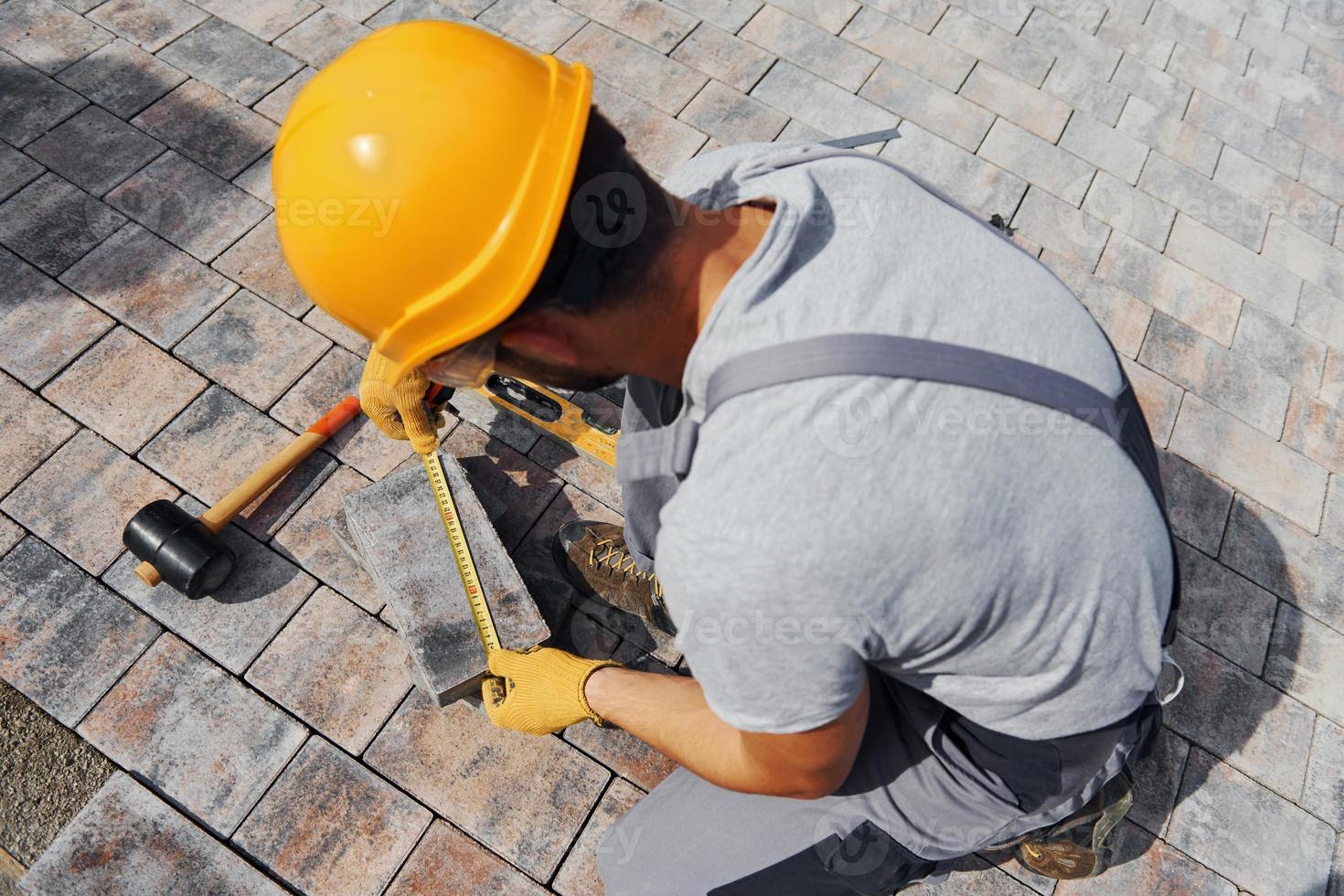 Measuring process. Male worker in yellow colored uniform have job with