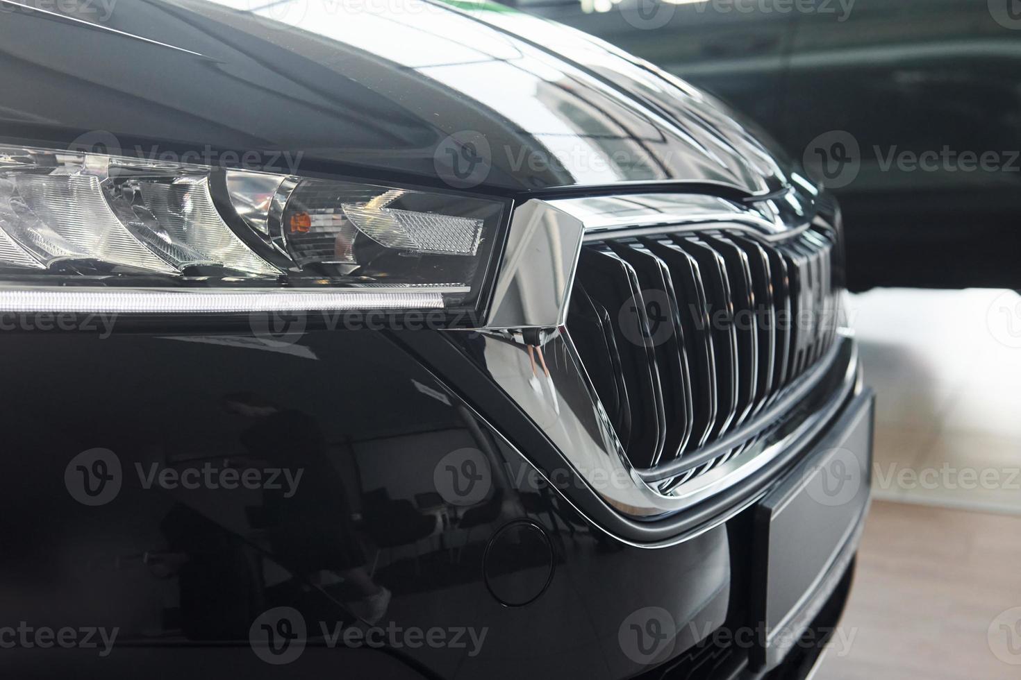Headlight of car. Close up focused view of brand new modern black automobile photo