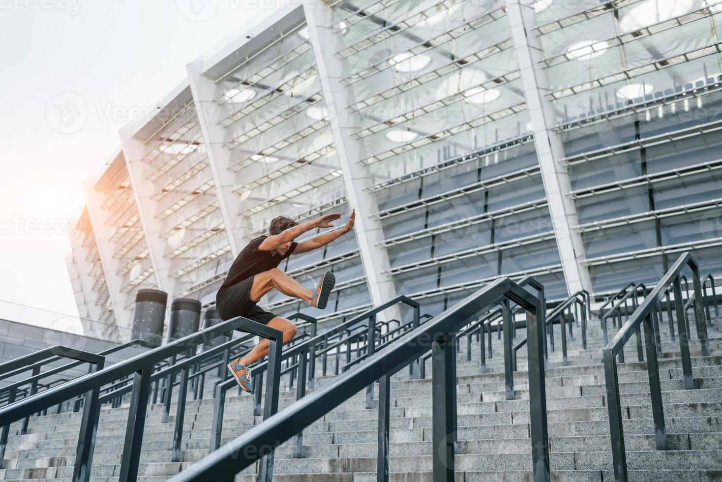 Young man in sportive clothes have workout outdoors at daytime photo