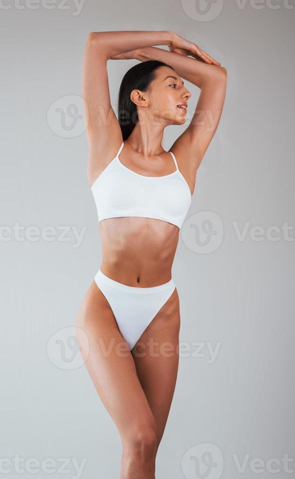 Premium Photo  Doing yoga exercises woman with sportive slim body type in  underwear that is in the studio