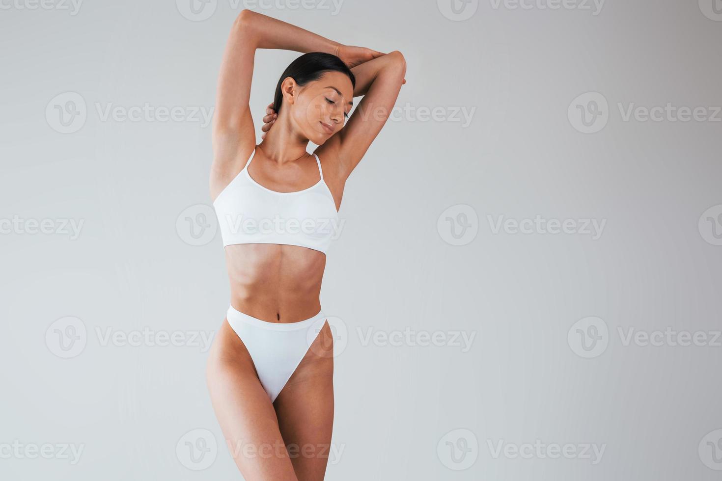 In white underwear. Woman with sportive slim body type that is in the  studio 15303569 Stock Photo at Vecteezy
