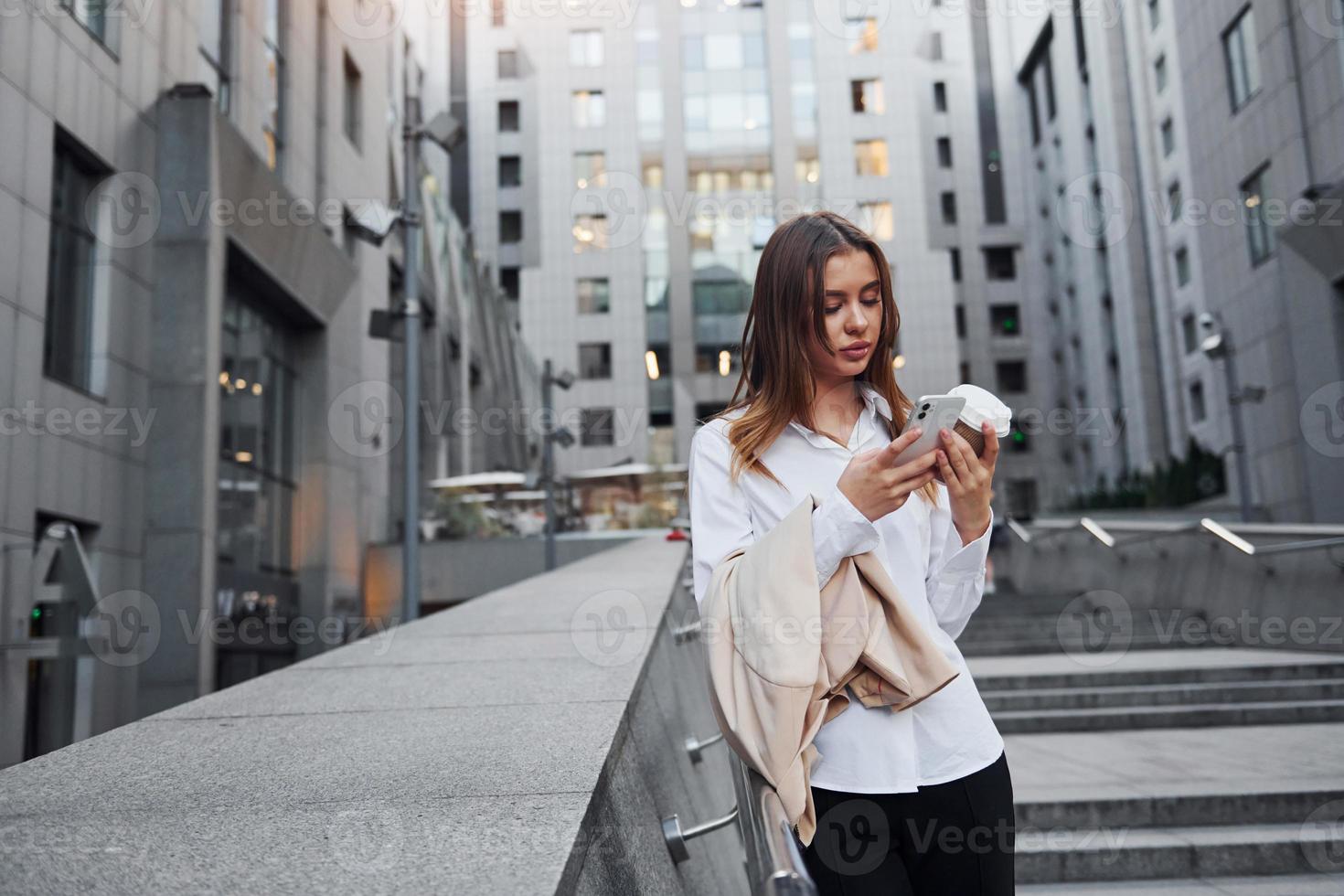 Beautiful young european woman is outdoors in the city at daytime photo